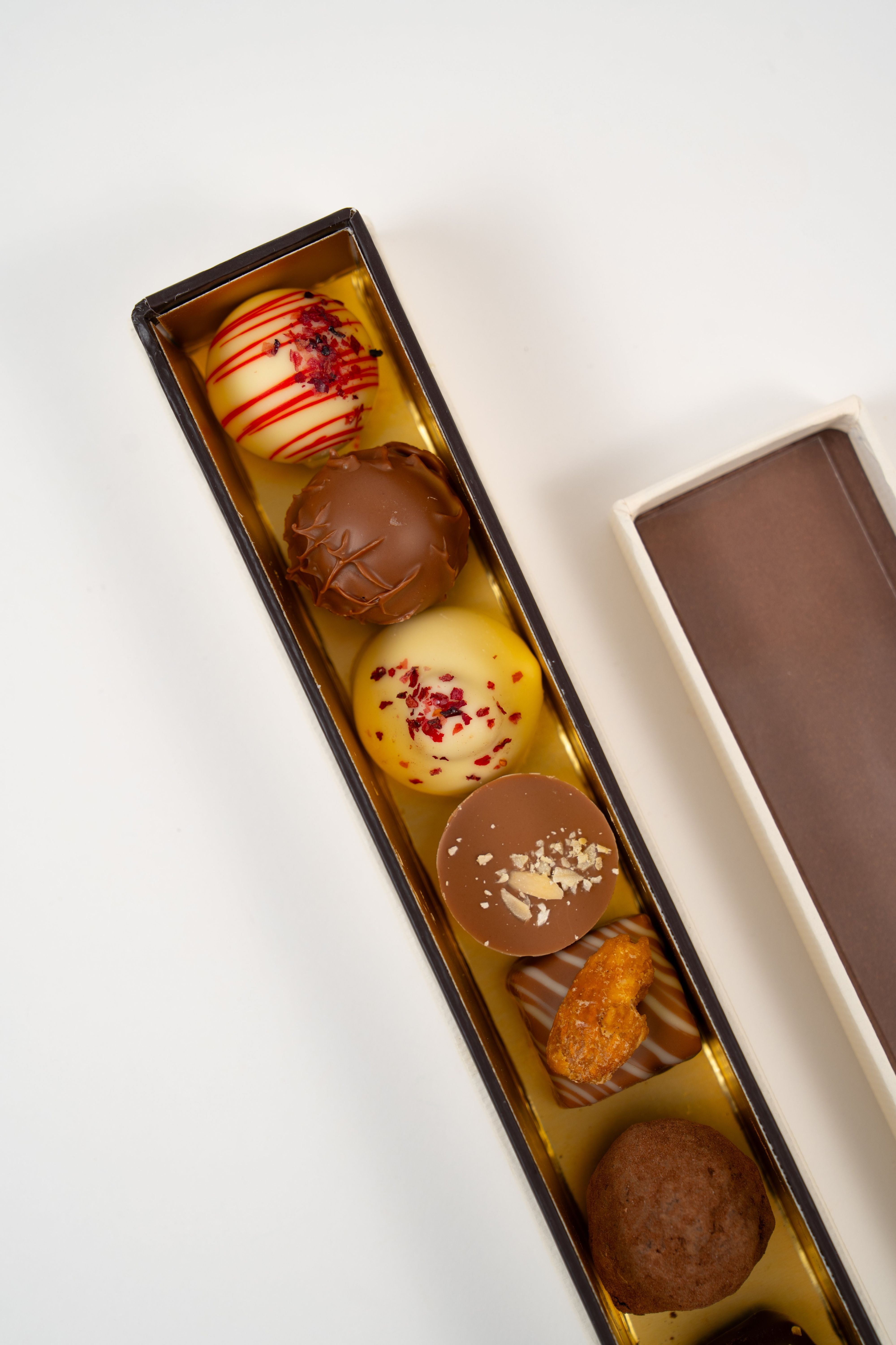 Assorted chocolate pralines selection box with eight handmade pralines including nougat, marzipan, vanilla cream and strawberry balsamic flavours.
