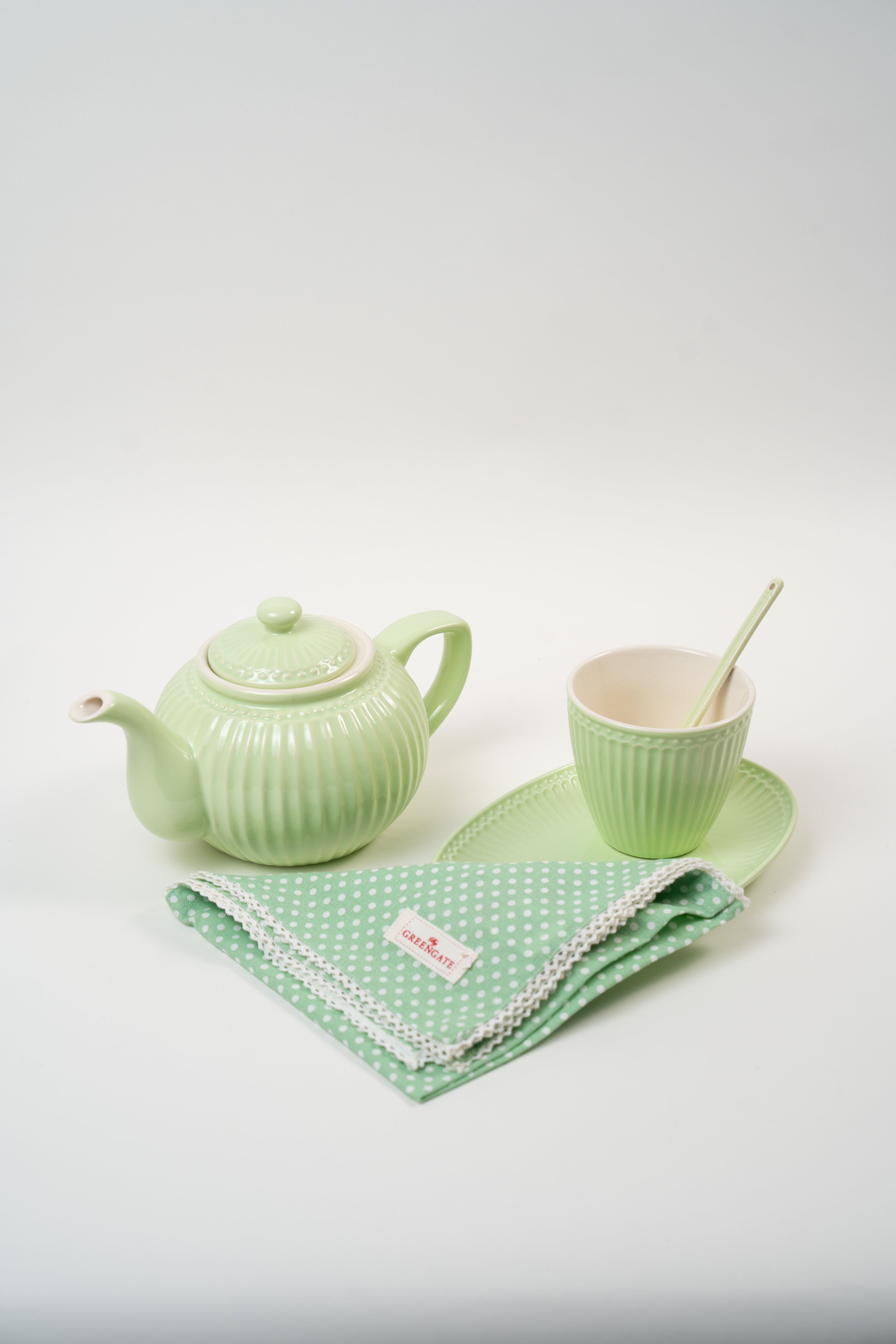 Alt text Top view of green teapot, cup and napkin from Art de la Table Vert Printemps collection