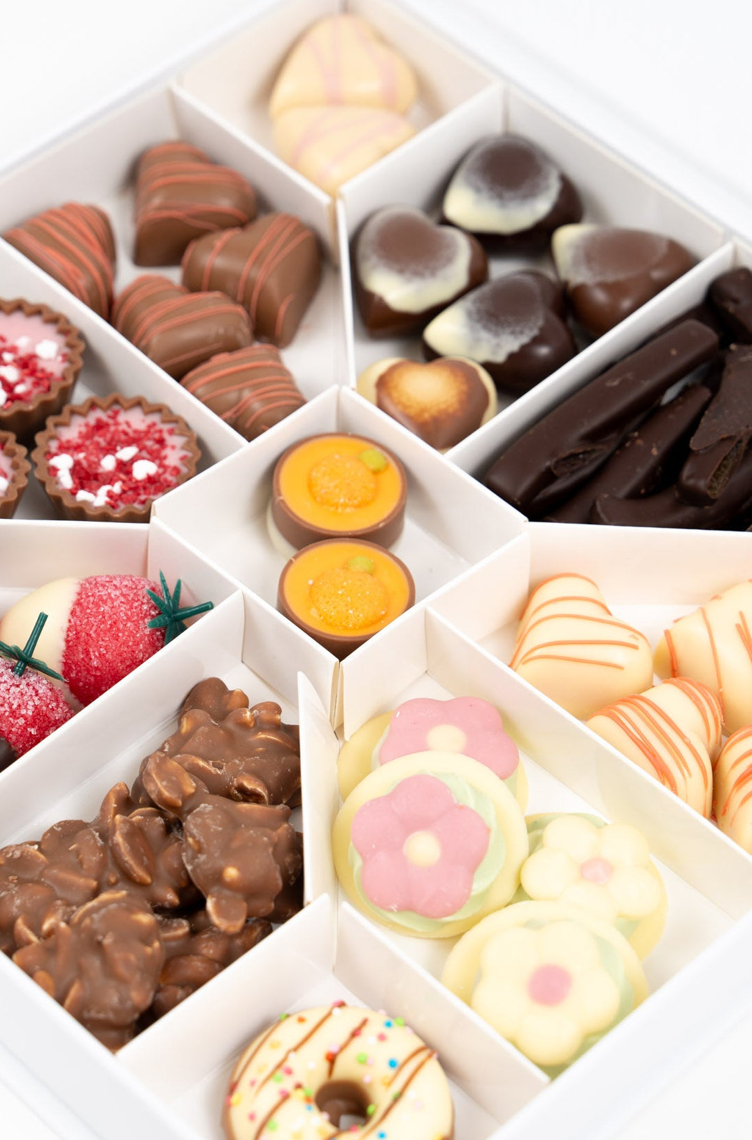 Détail d’un assortiment de chocolats artisanaux avec pralinés, ganaches fruitées et douceurs chocolatées premium