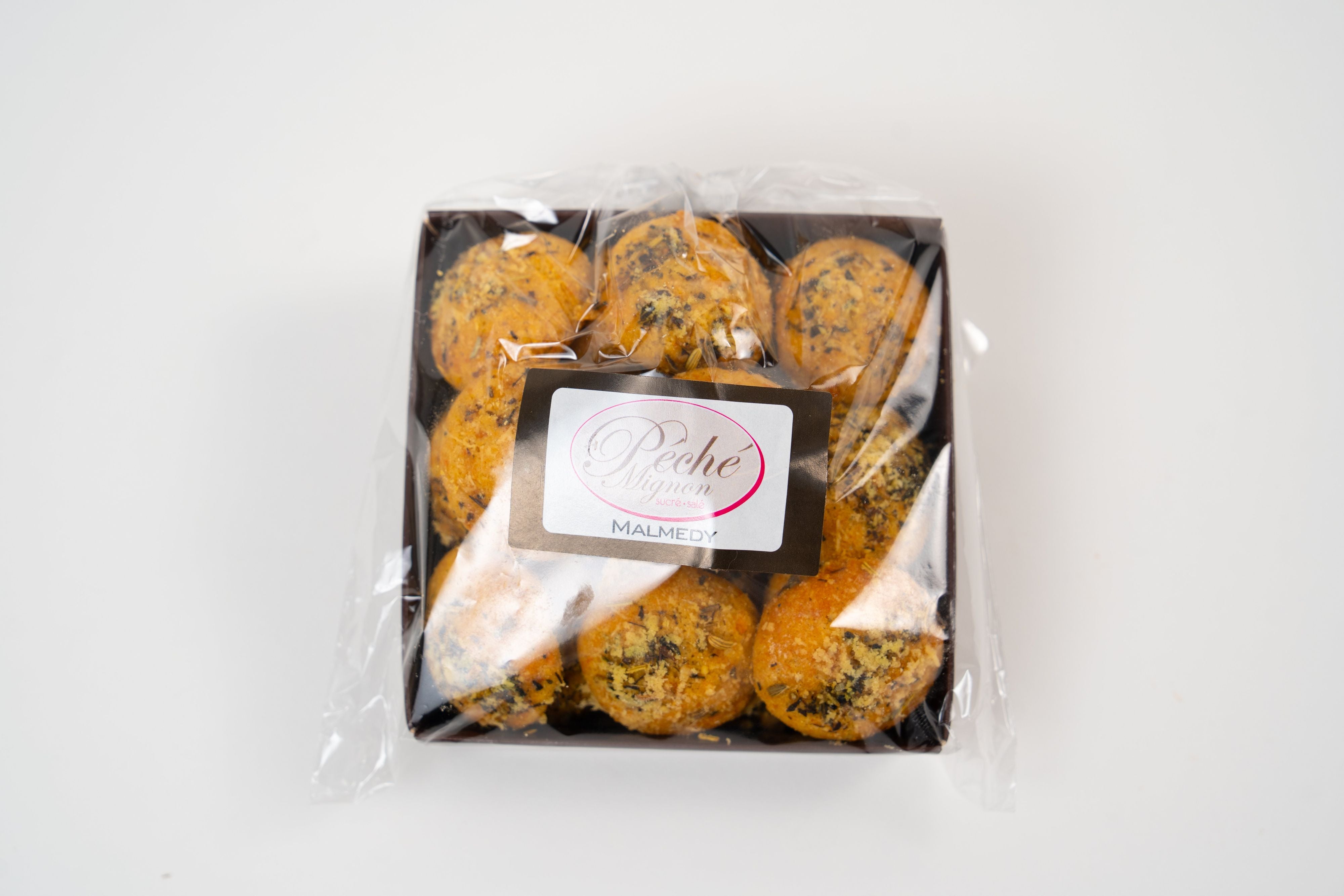 Présentation d'un sachet de biscuits au fromage dans un panier cadeau gourmet avec du vin.