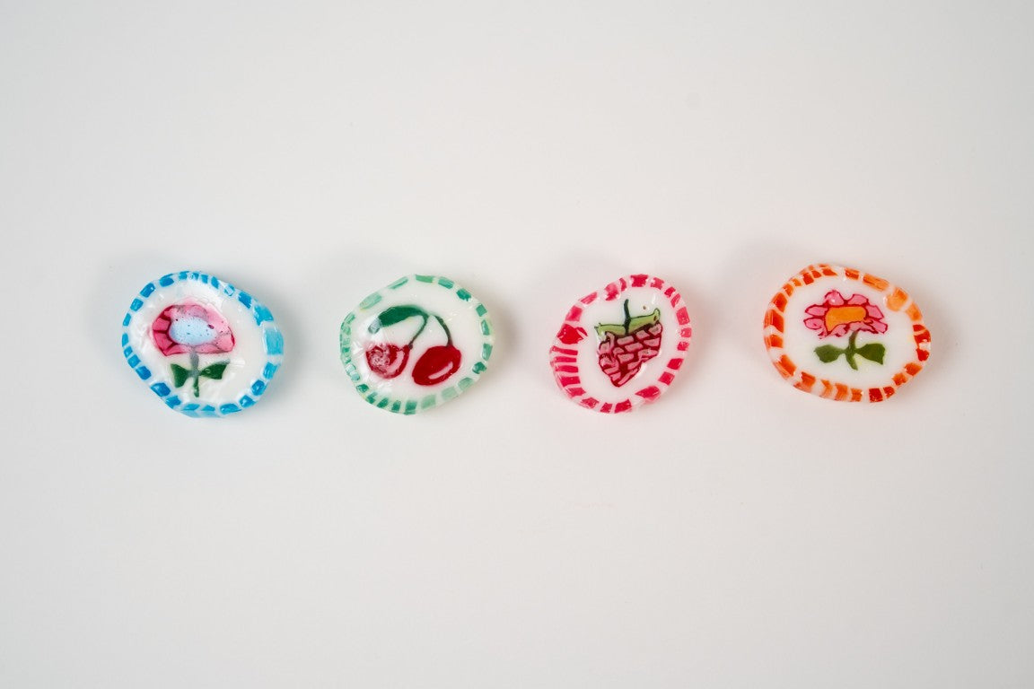 mini bonbons fruités colorés alignés sur fond blanc