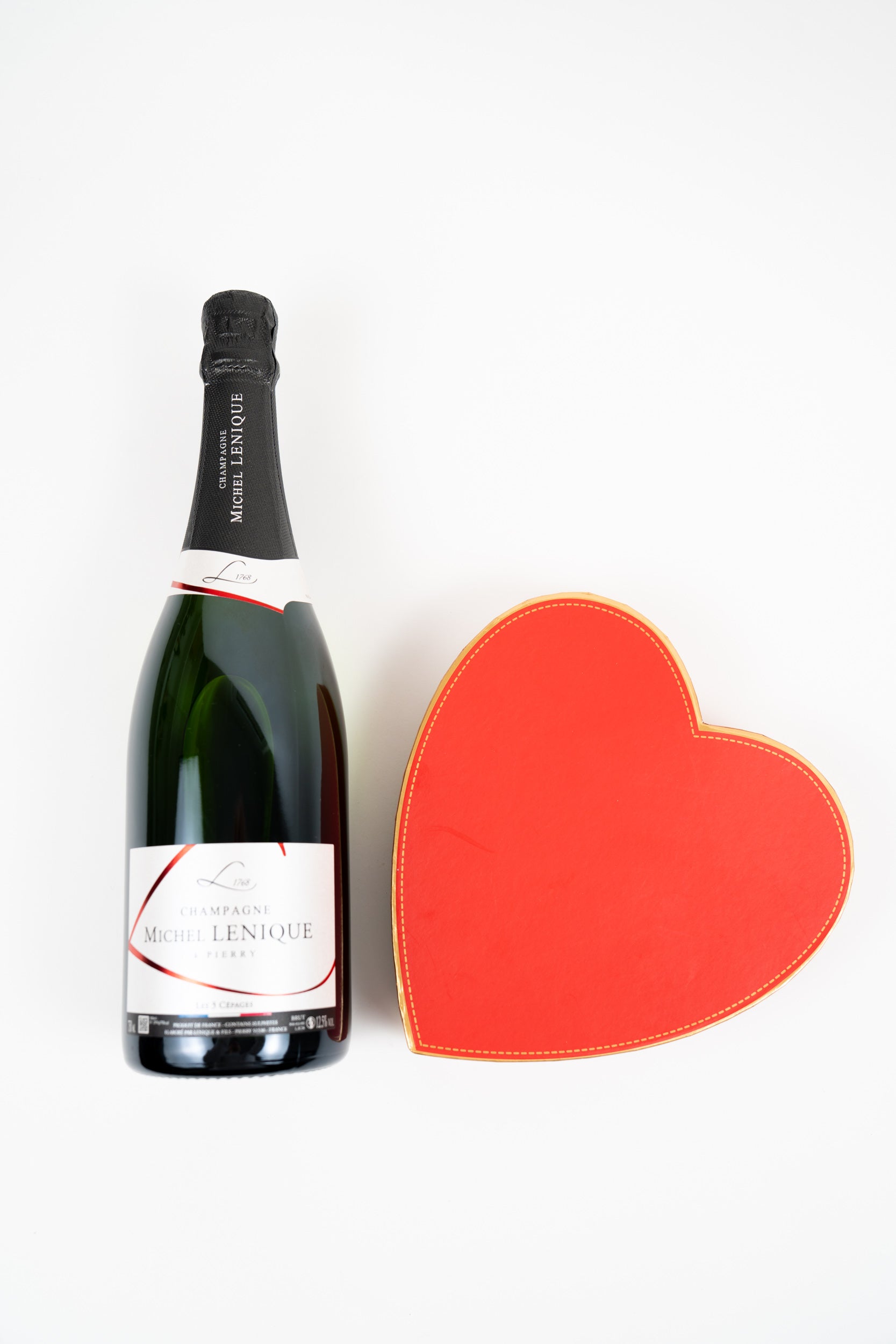 Champagne bottle with closed red heart-shaped gift box, elegant romantic gift set