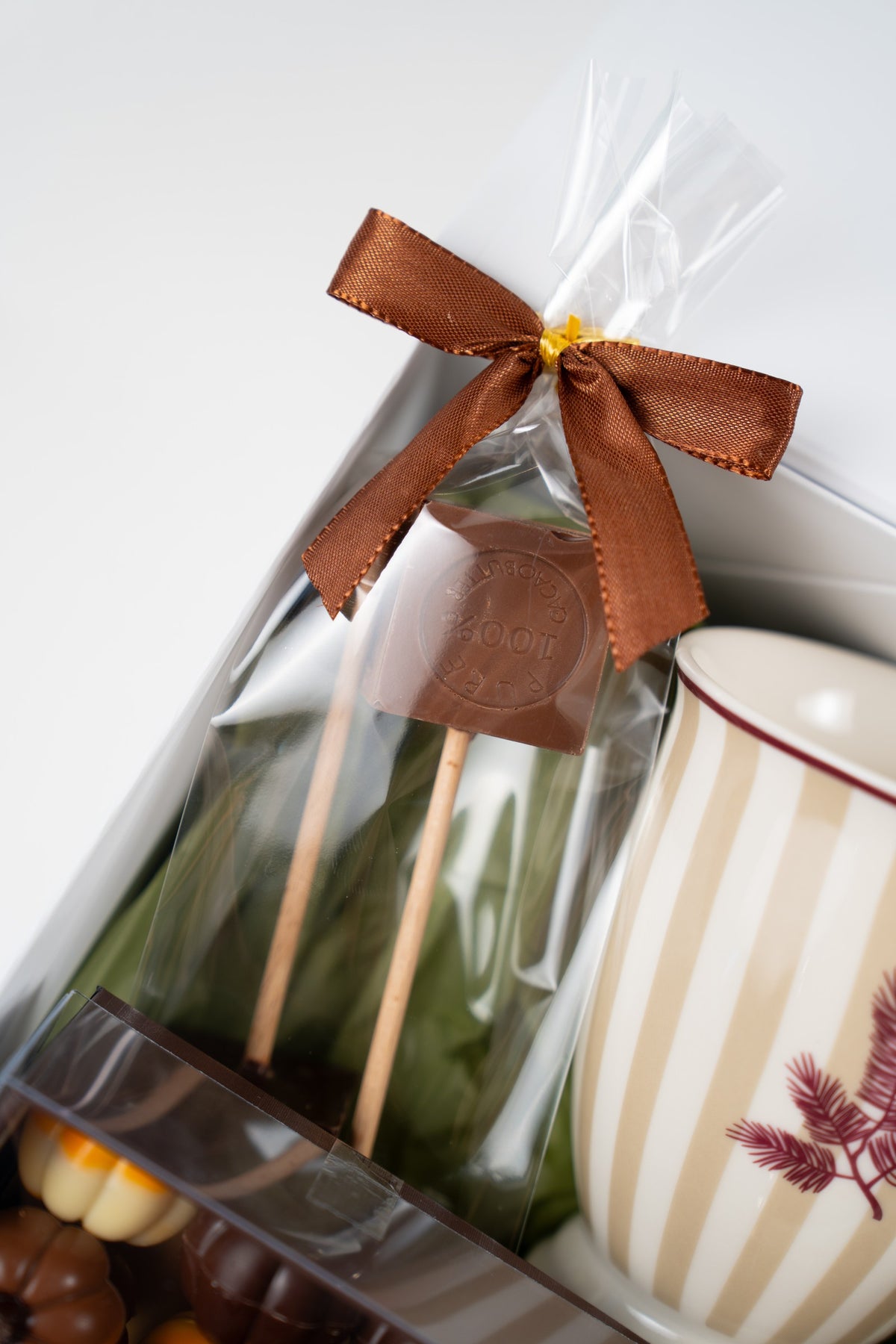 Artisan dark hot chocolate cubes on sticks, wrapped in a clear bag with a brown ribbon.