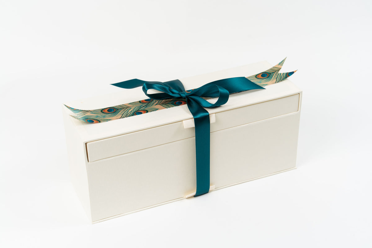 Coffret Champagne & Pralines fermé avec ruban, bouteille de champagne et boîte de pralines