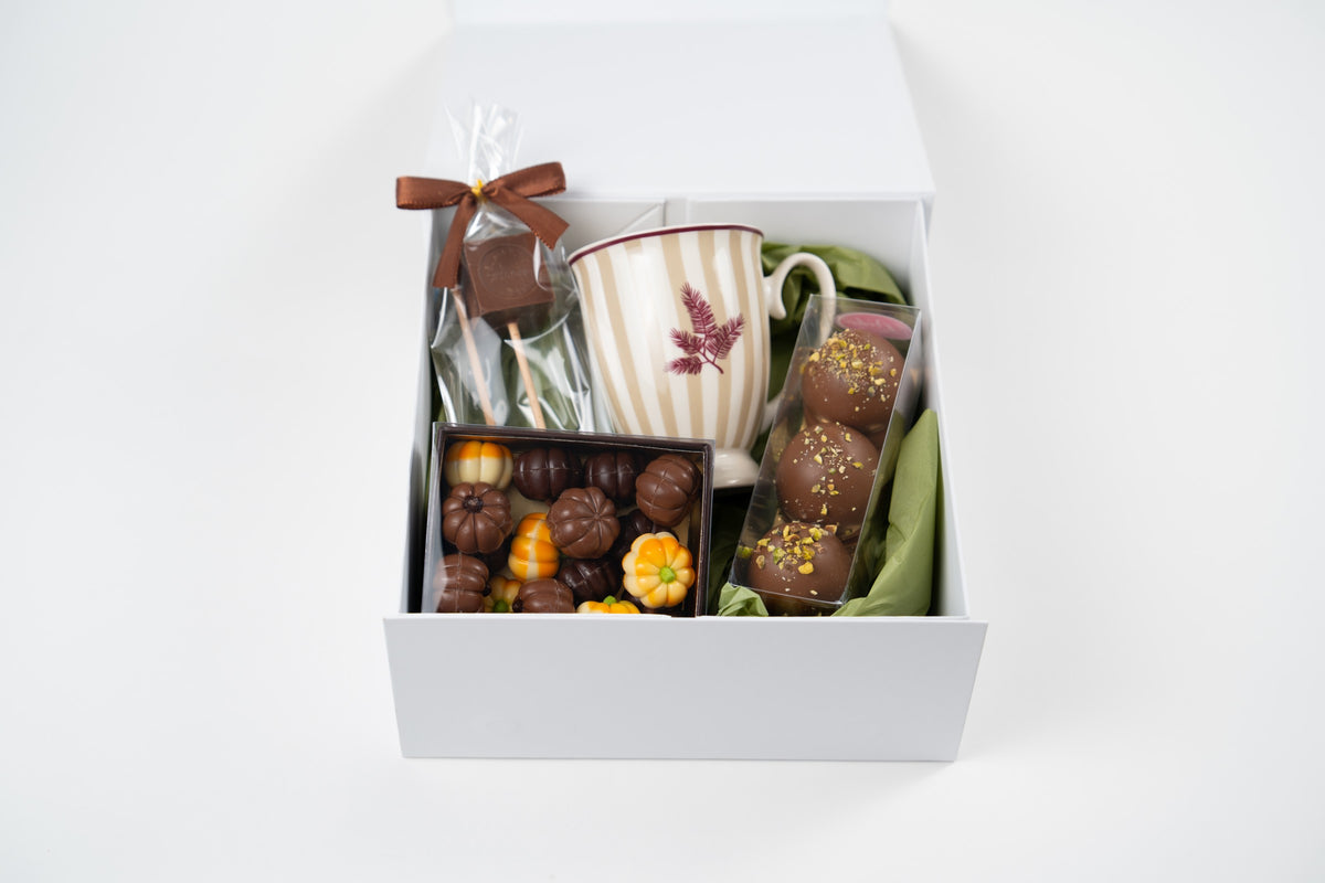 Front view of the autumn hot chocolate gift box with Naemi mug, chocolate pumpkins, Dubai pistachio Melocakes and hot chocolate cubes.