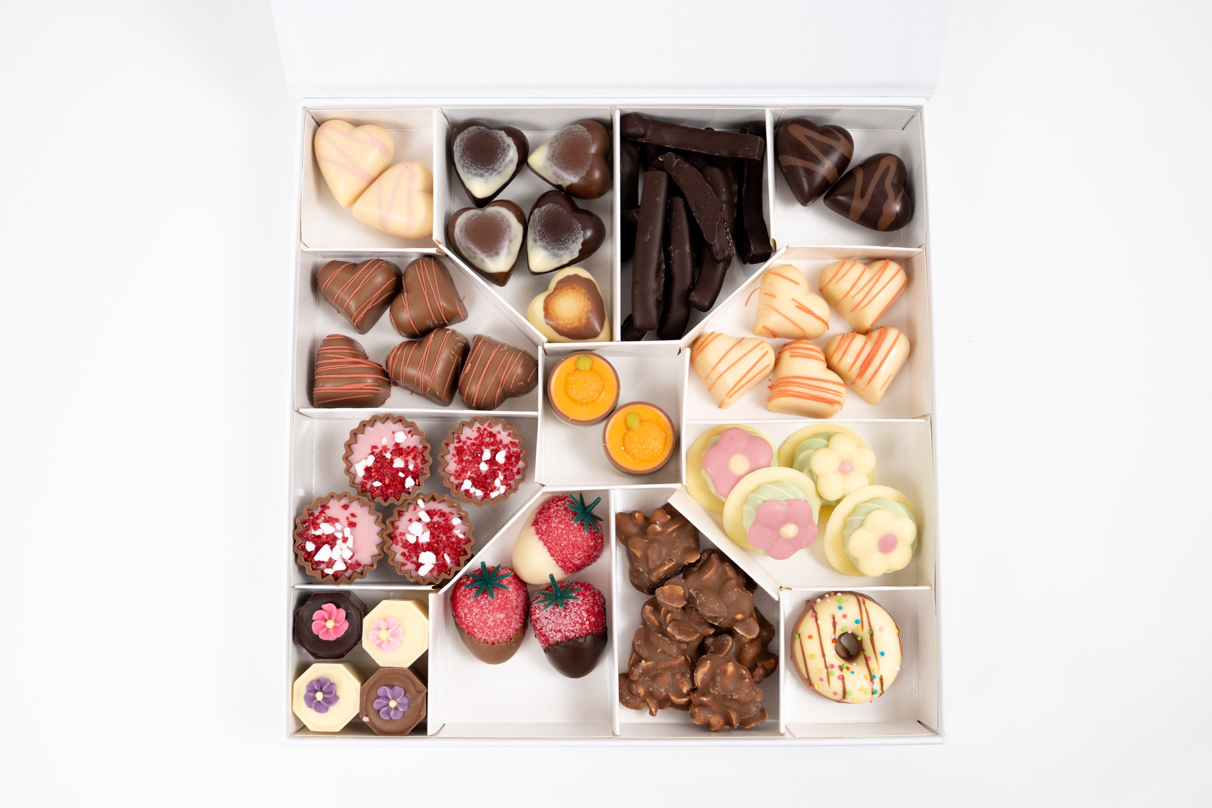 Vue de dessus d’un coffret chocolat premium avec assortiment de chocolats artisanaux et spécialités gourmandes