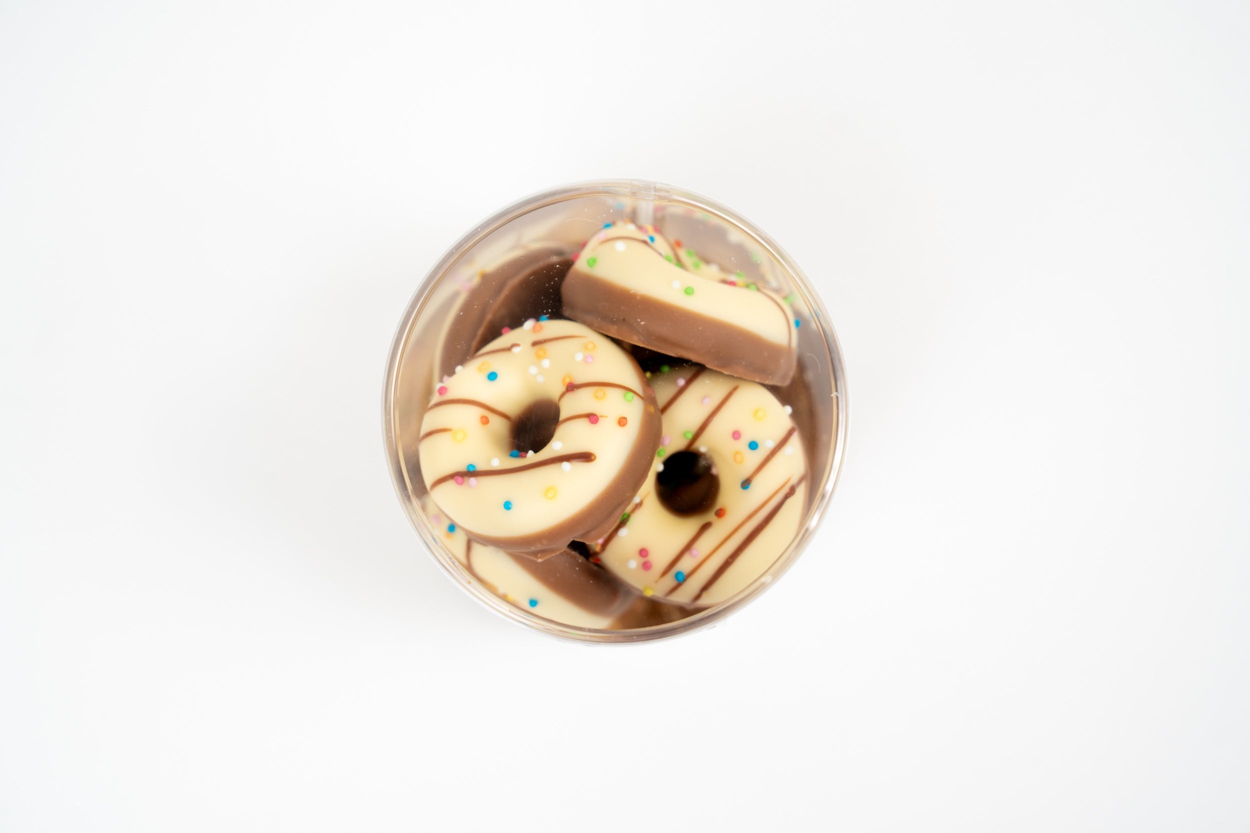 Donut shaped milkshake chocolates with white and milk chocolate coating and colourful sprinkles