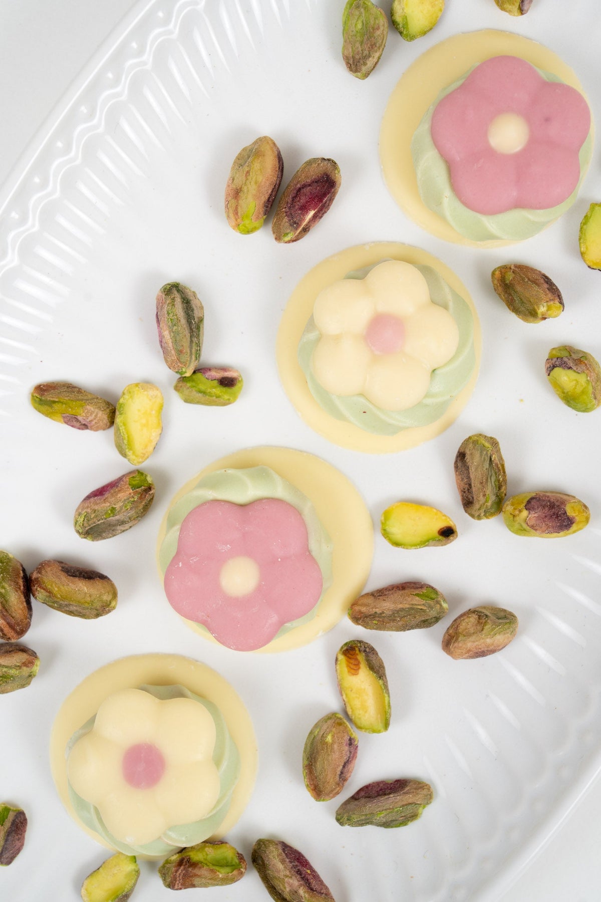 Belgische bloemen van melk-, witte en roze chocolade gevuld met pistachecrème
