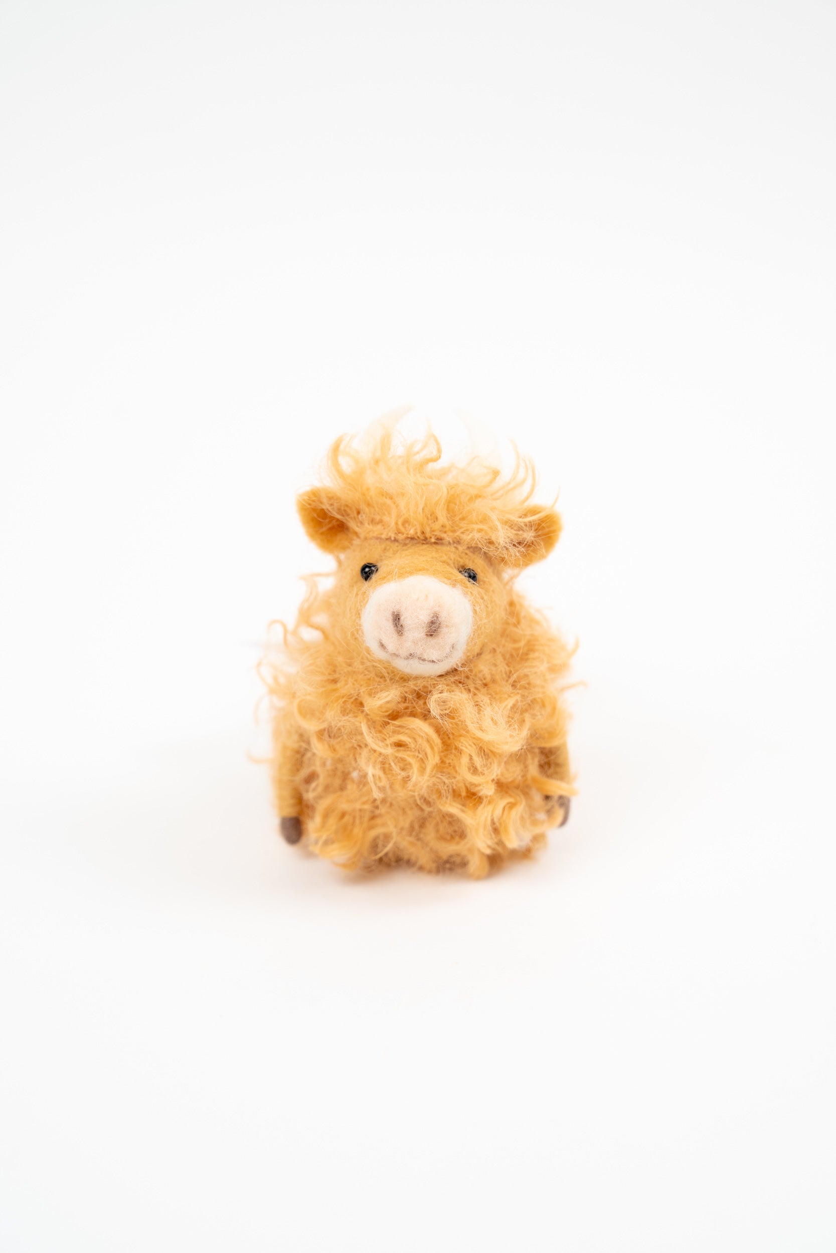 Gry & Sif golden curly felt cow figure on a clean white background.