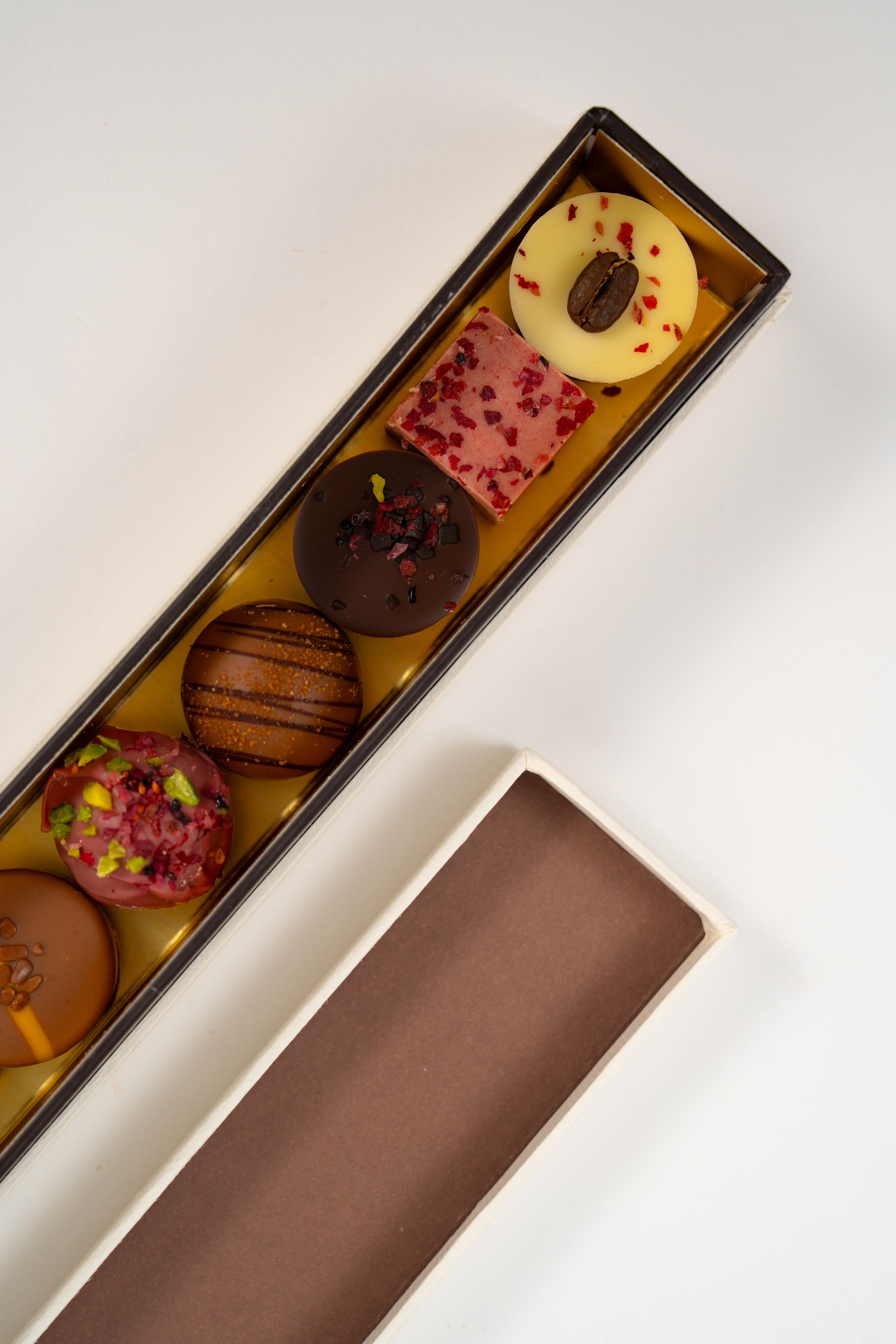 Luxury assortment of handcrafted pralines including pistachio, caramel, raspberry and coffee chocolates