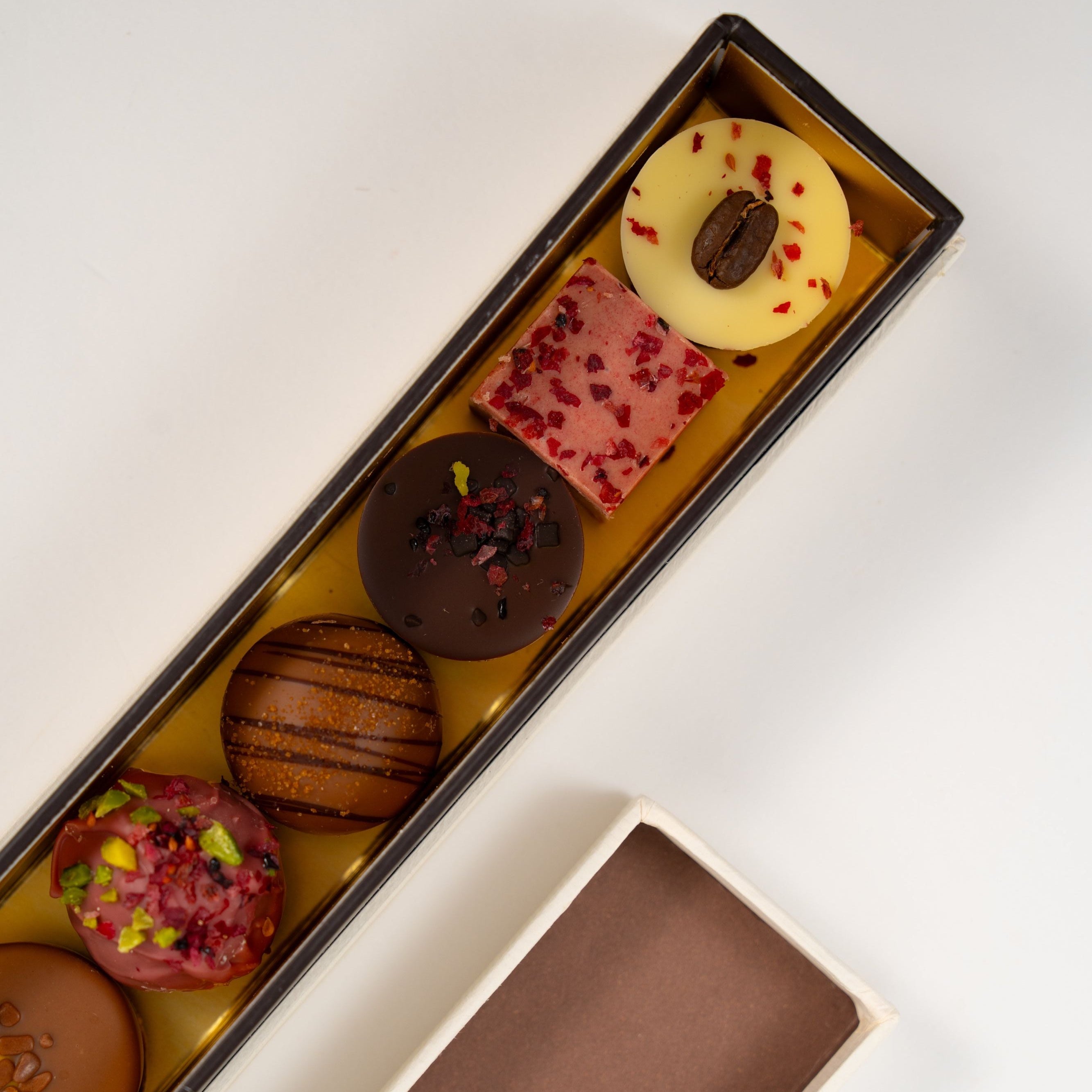 Assortment of handcrafted pralines including pistachio, caramel, raspberry and coffee chocolates