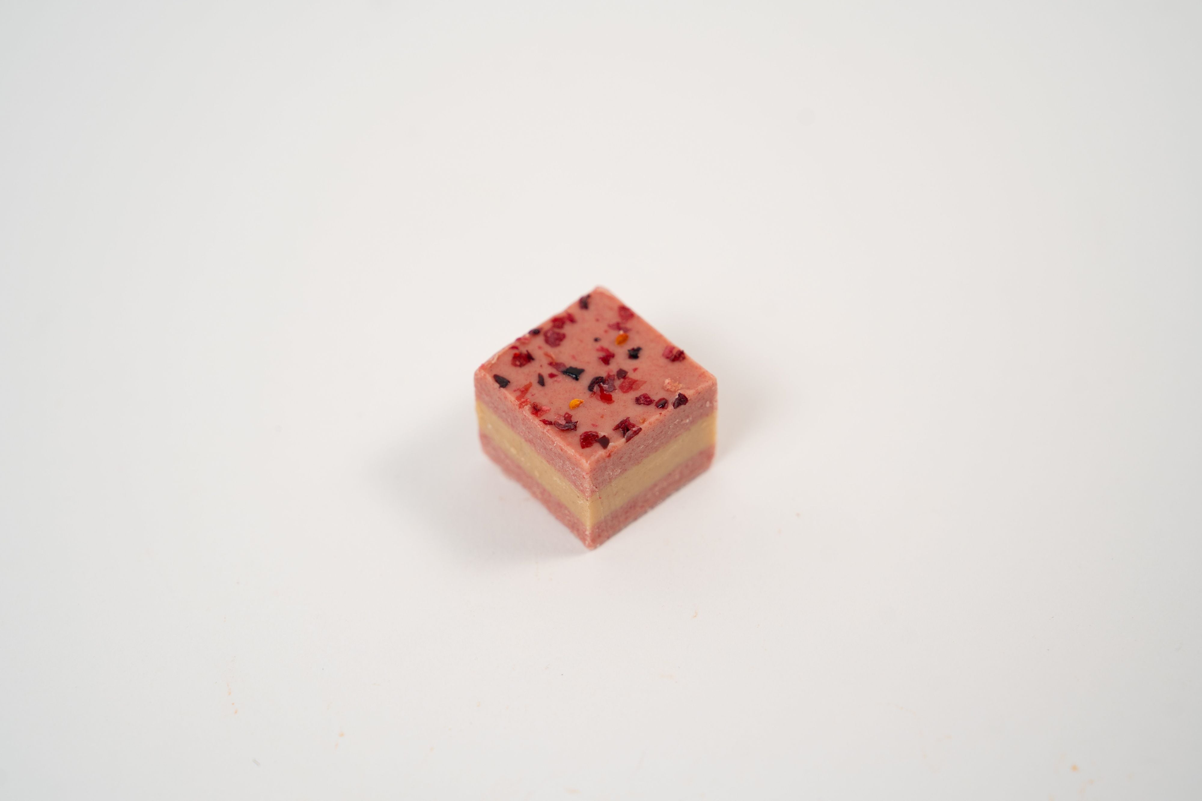 Raspberry nougat praline with hazelnut and raspberry pieces