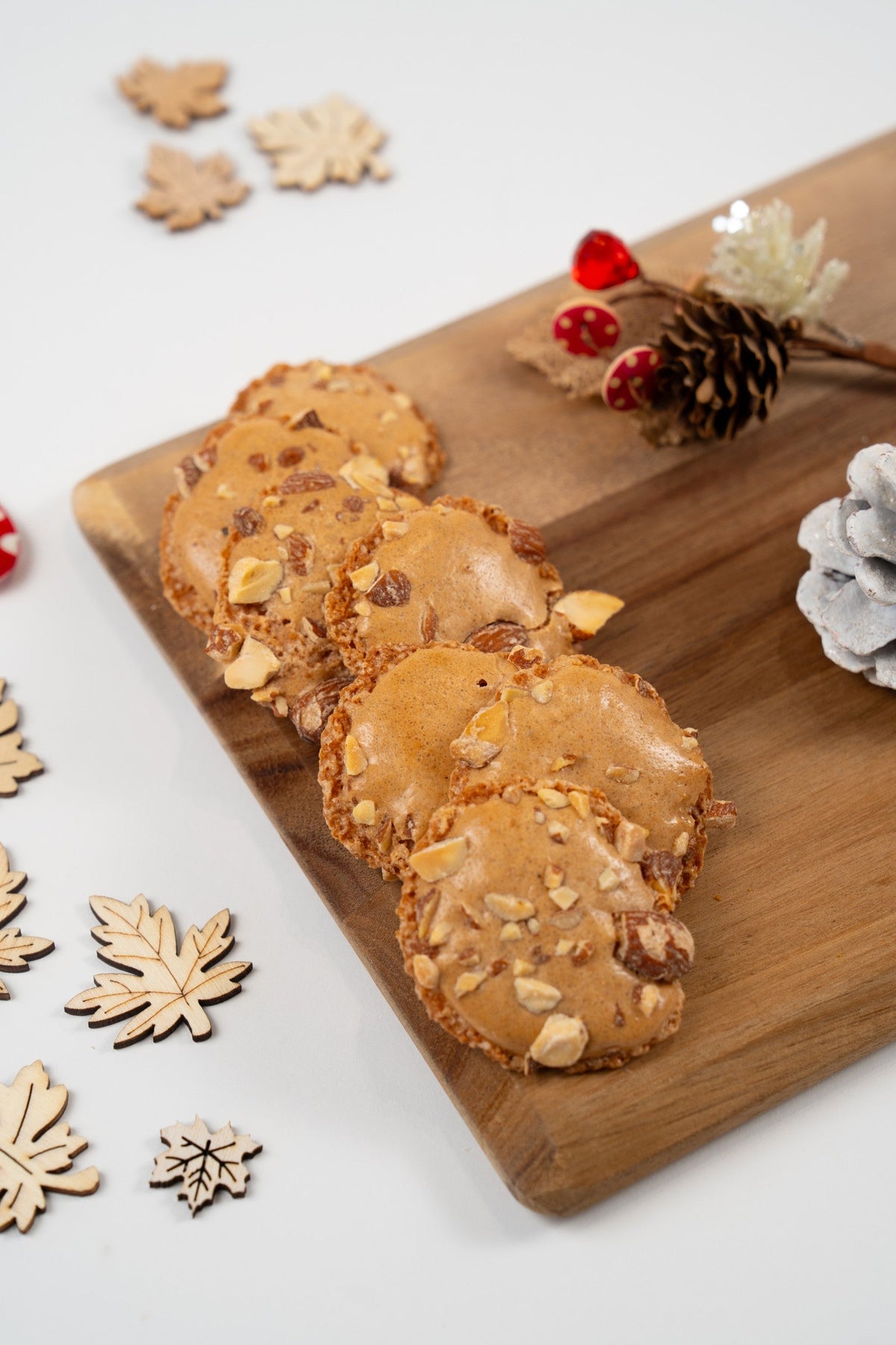 Merengues belgas de almendra con almendras enteras y picadas sobre una tabla de madera.