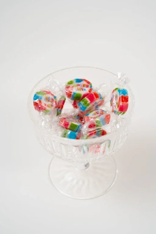 Mini caramelos Happy Birthday coloridos en una copa transparente