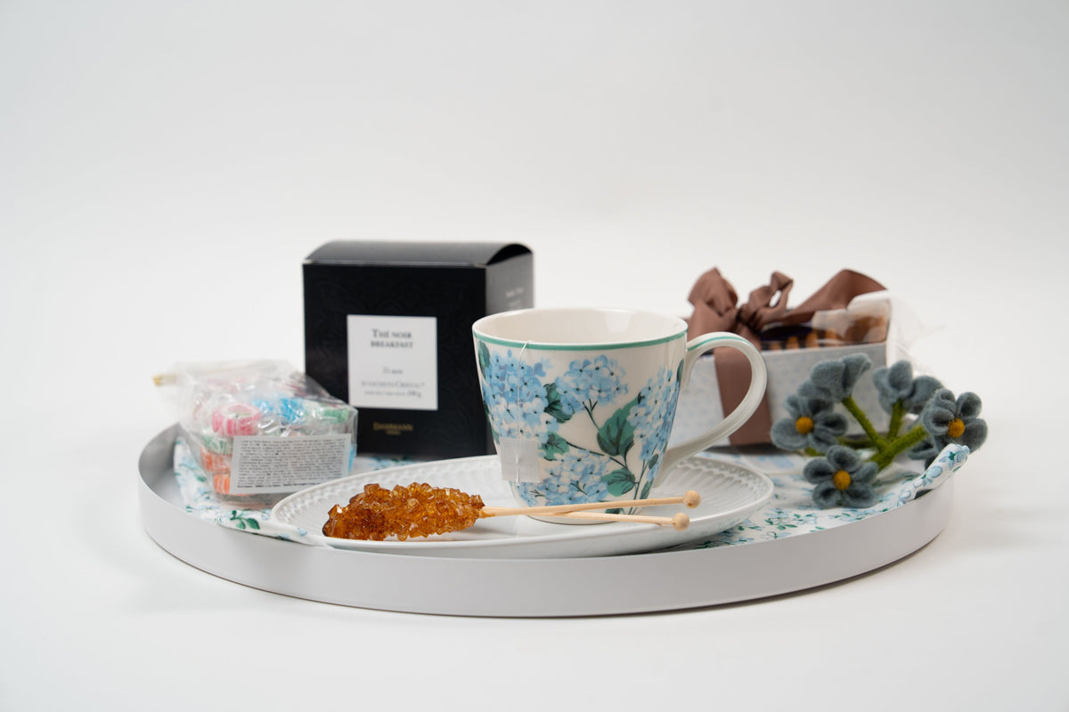 Péché Mignon tea gift set with breakfast tea, biscuits, sweets and floral teacup