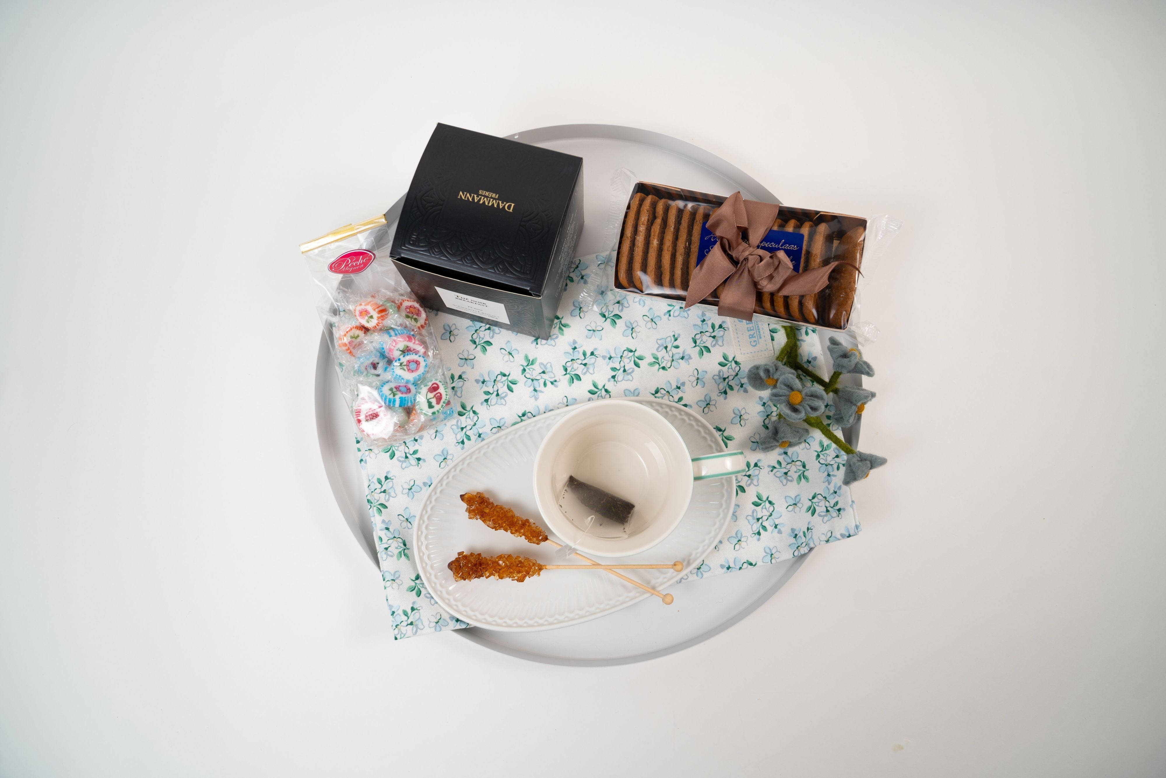 Top view of Péché Mignon tea and biscuit breakfast gift set with sweets and sugar sticks