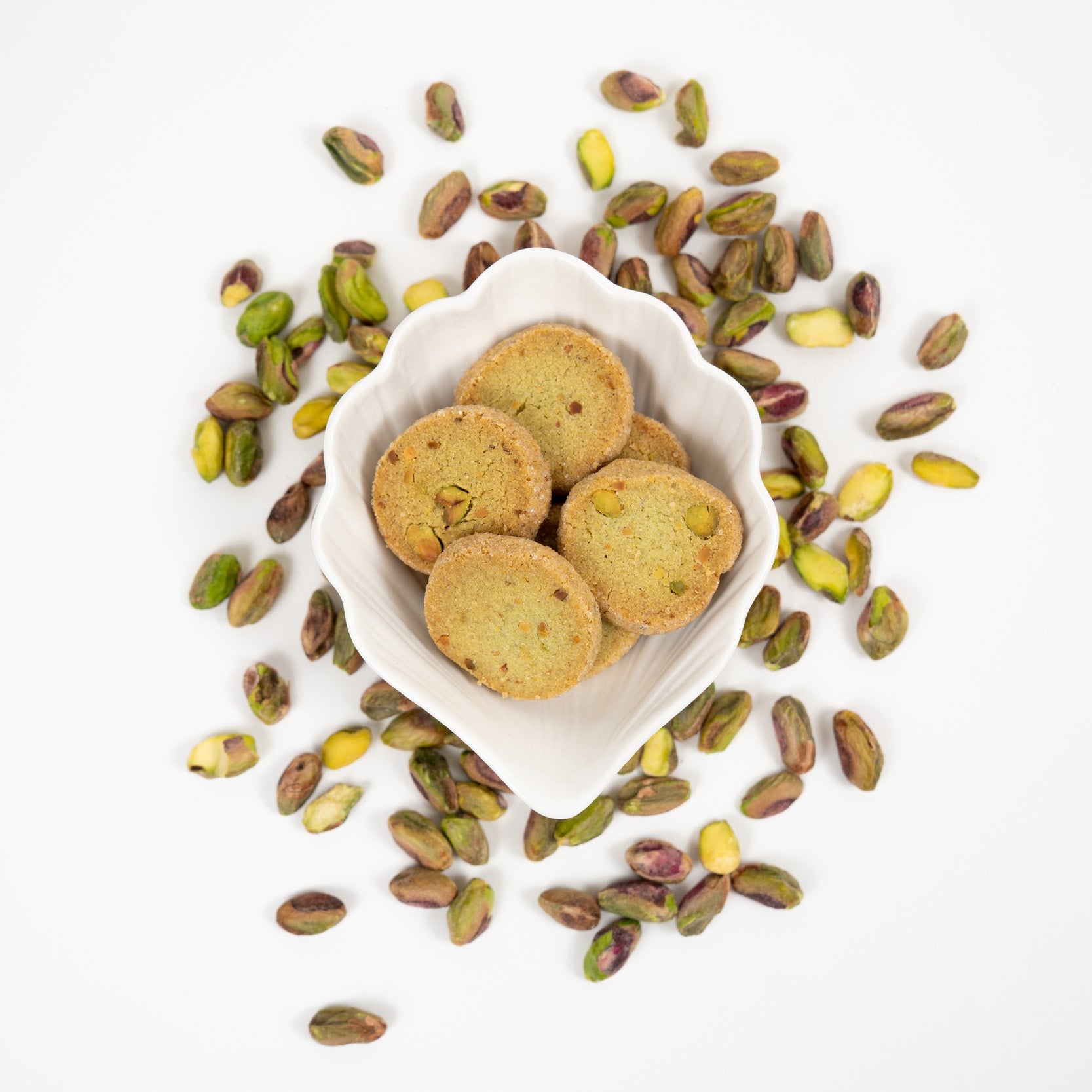 Artisan pistachio biscuits with whole pistachios in a bowl