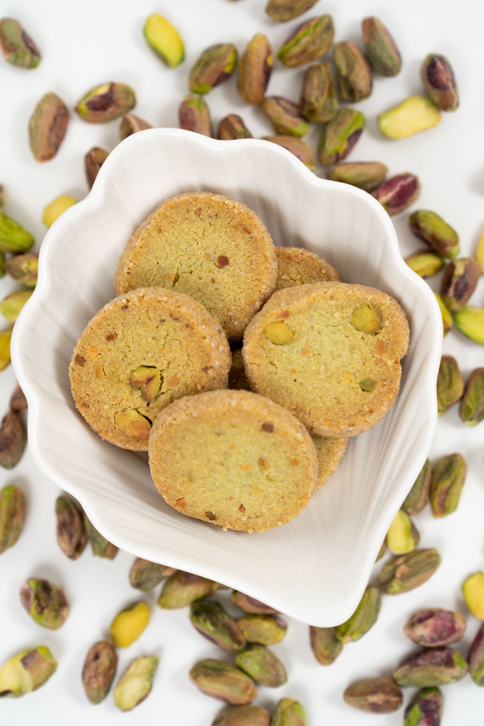 Close-up of pistachio sablé biscuits with visible pistachio pieces