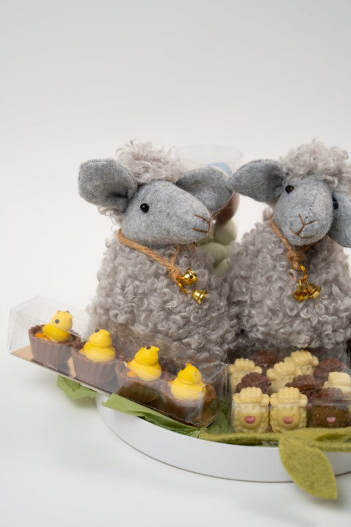 Gourmet Easter platter with grey decorative lambs, pralines and Easter chocolates from Le Péché Mignon.