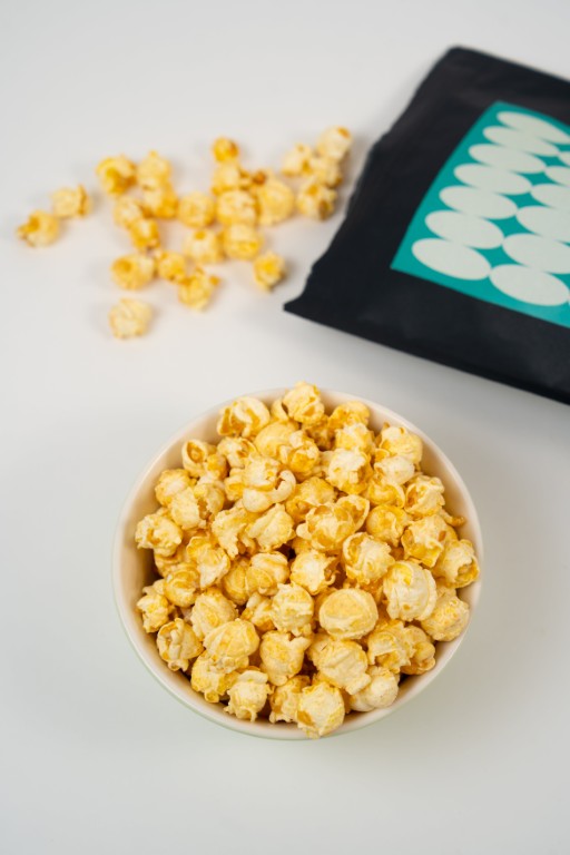 Gros plan sur du popcorn artisanal Birnenbengel à la poire. Grains croustillants enrobés d'un glaçage blanc et de pulpe de poire caramélisée.