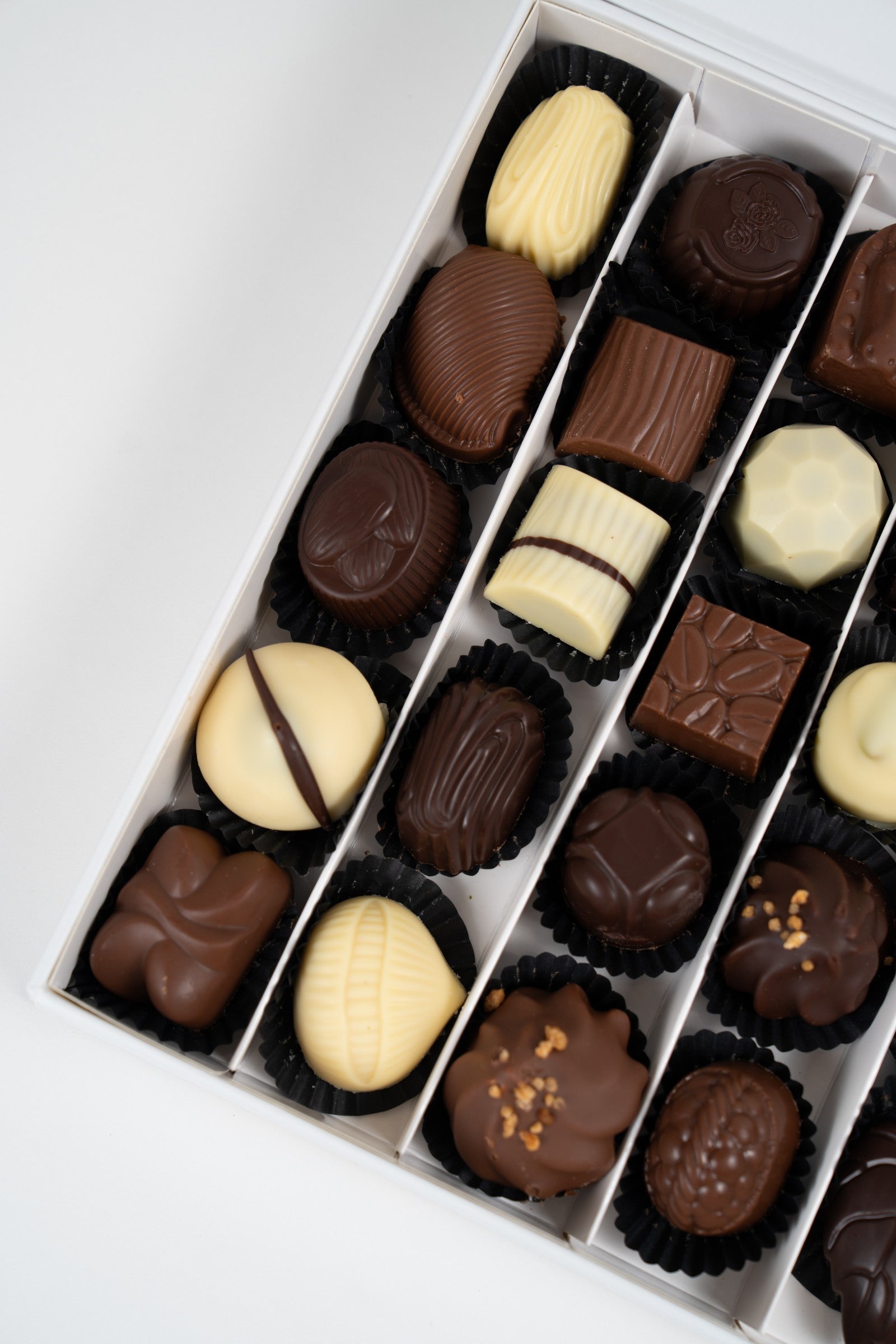Vue rapprochée de pralines artisanales belges aux finitions colorées et brillantes