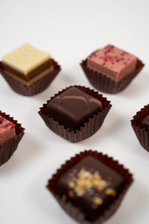 Assortiment de pralinés nougat vegan aux noisettes et framboises, cadeau gourmand.