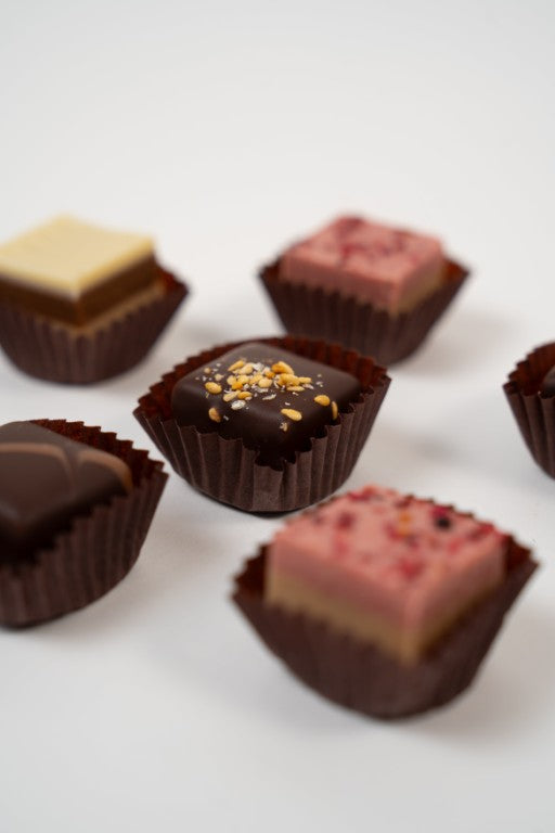 Assortiment de pralinés nougat vegan aux noisettes et framboises, cadeau gourmand.