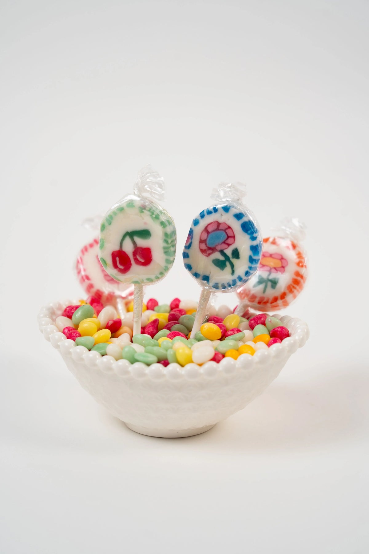 Multicoloured artisan lollipops with fruit and flower motifs
