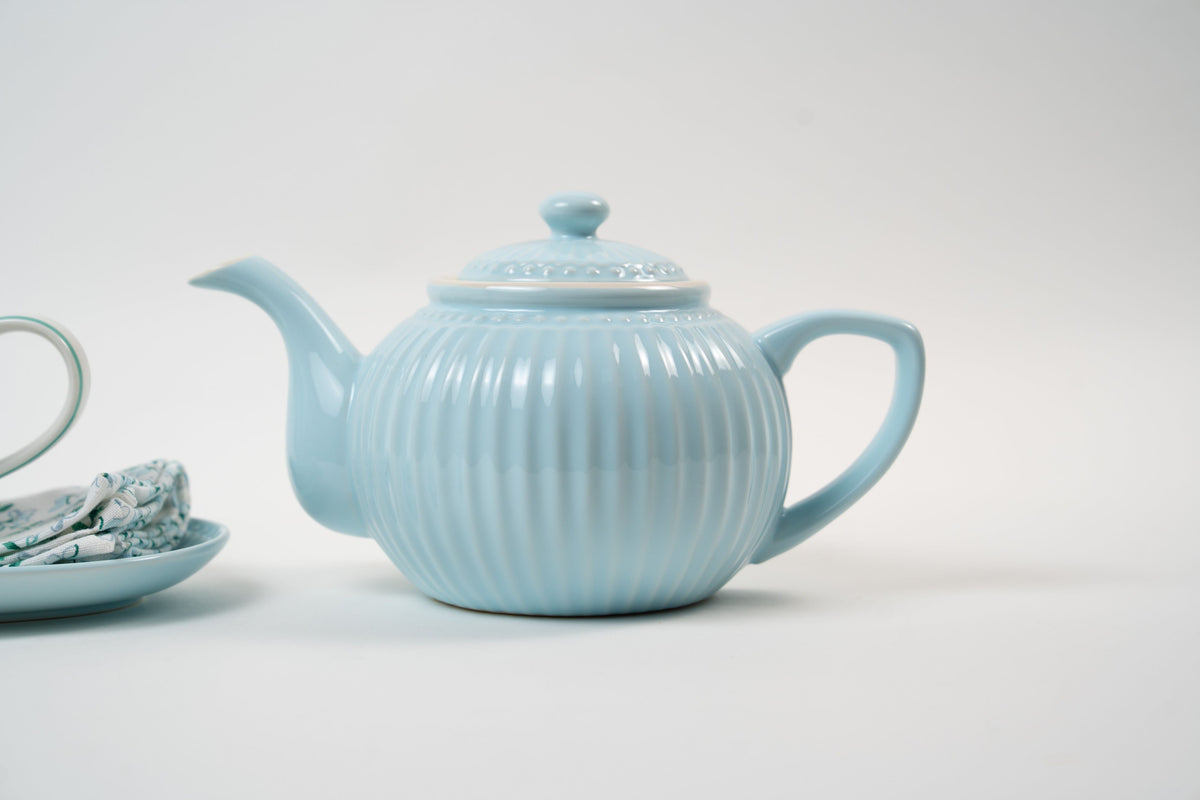 Théière en céramique bleu pastel au design délicatement nervuré et aux finitions élégantes. Une pièce intemporelle qui apporte une touche de douceur et de raffinement à votre table.