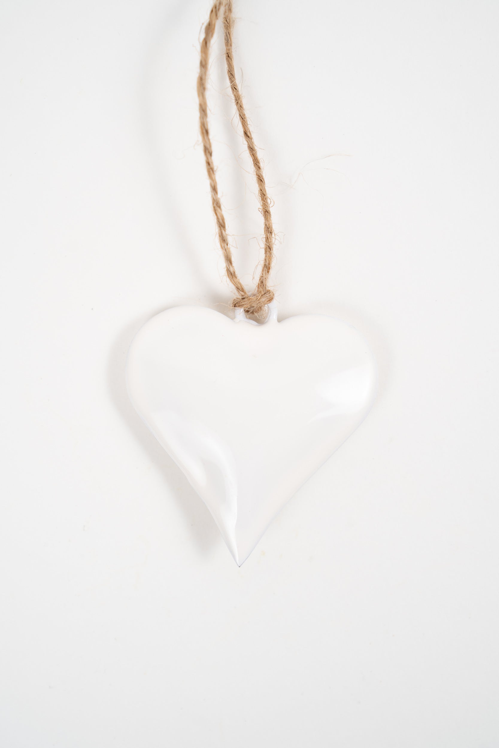 White ceramic heart hanging decoration with a natural jute cord on a clean white background.