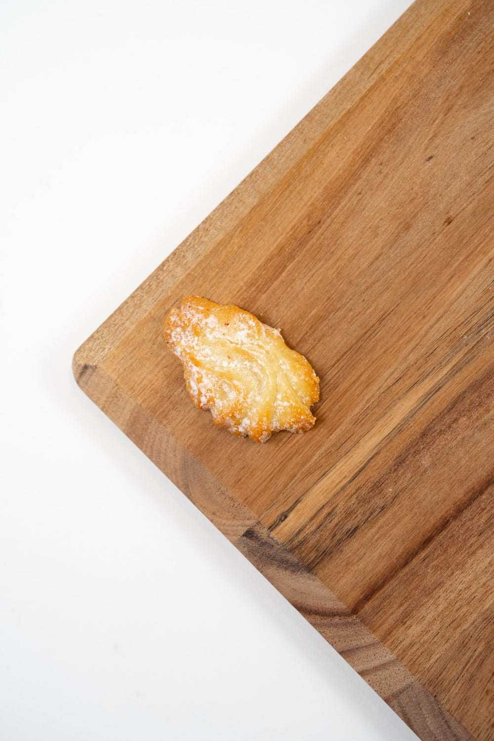 Wiener Classic, sablé viennois au beurre légèrement poudré, présenté sur une planche en bois.