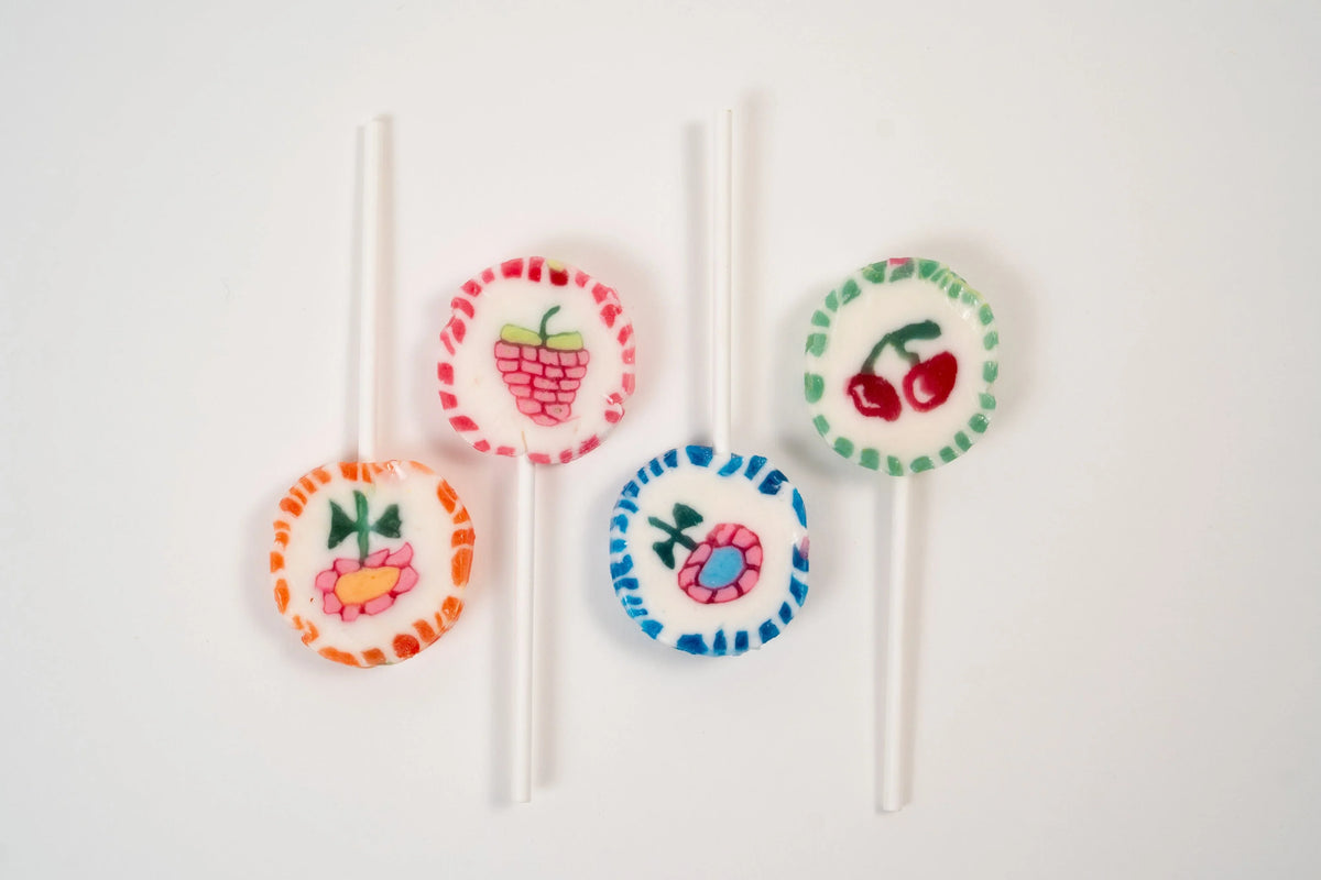 Assortment of colourful artisan lollipops with cherry, raspberry and flower motifs