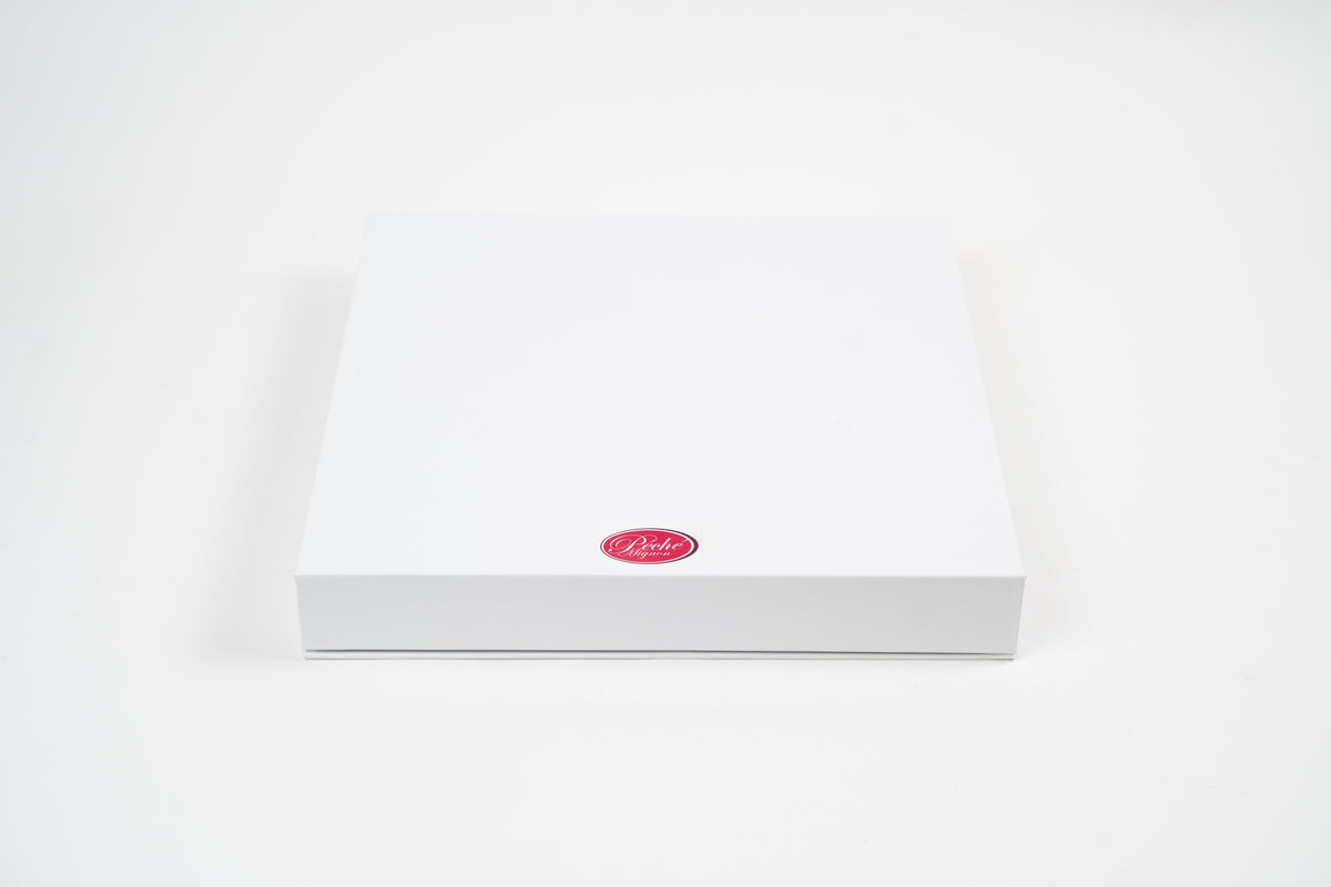 Gesloten geschenkdoos van Péché Mignon op een witte achtergrond