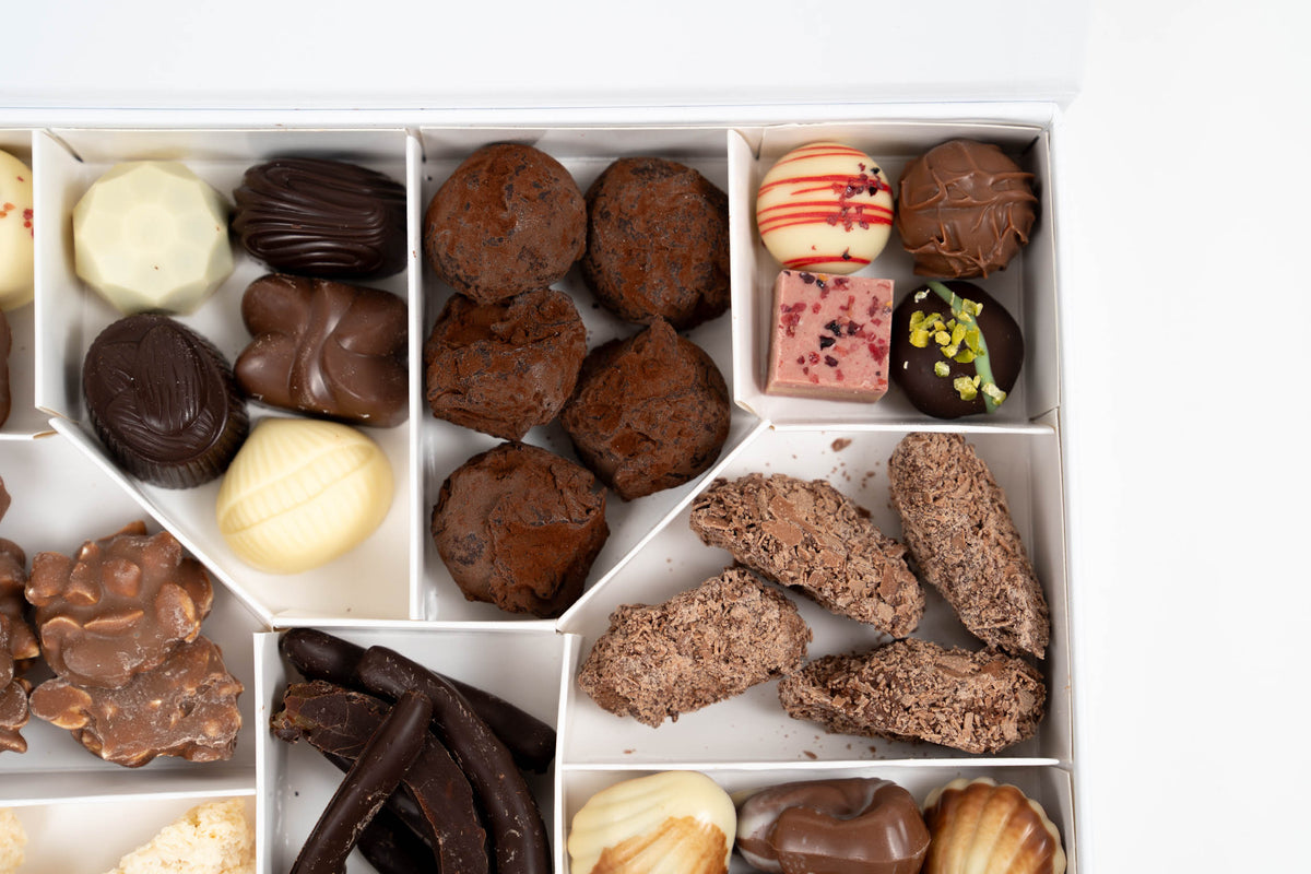 Detailopname van pralines, chocoladezeevruchten en zoetigheden in de geschenkdoos