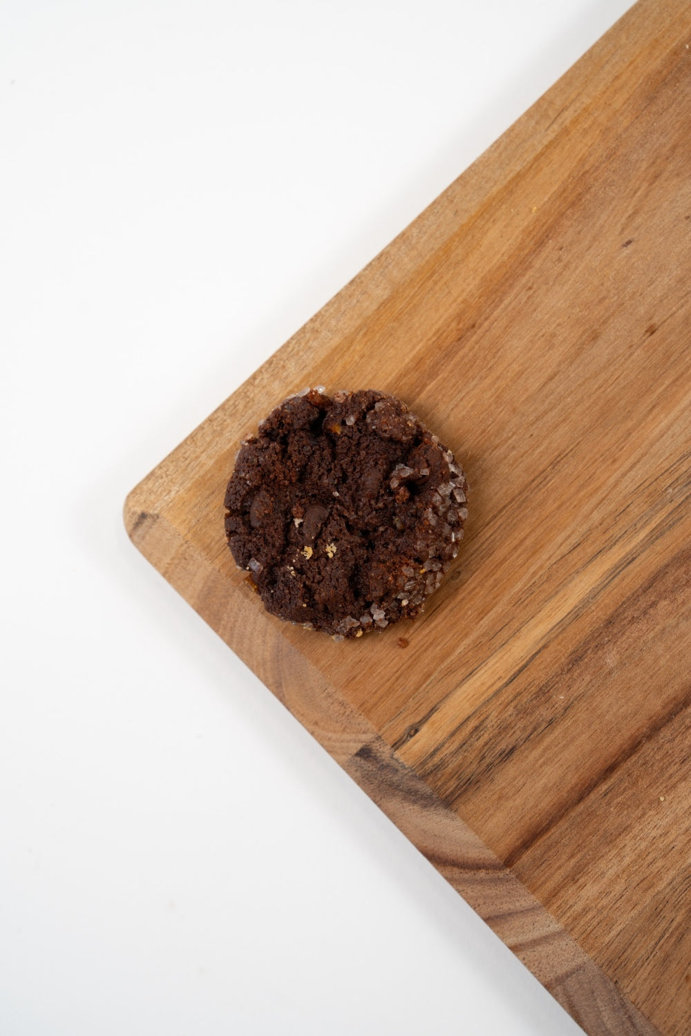 Biscuit artisanal au chocolat de l’assortiment Péché Mignon, présenté sur une planche en bois.