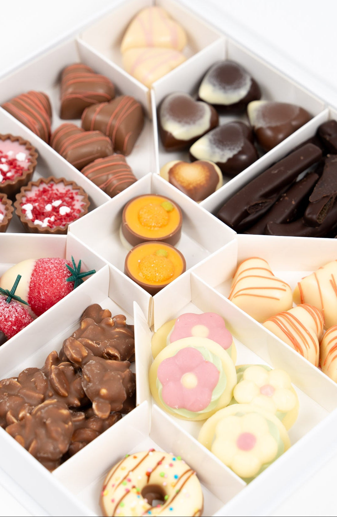 Détail d’un assortiment de chocolats artisanaux avec pralinés, ganaches fruitées et douceurs chocolatées premium