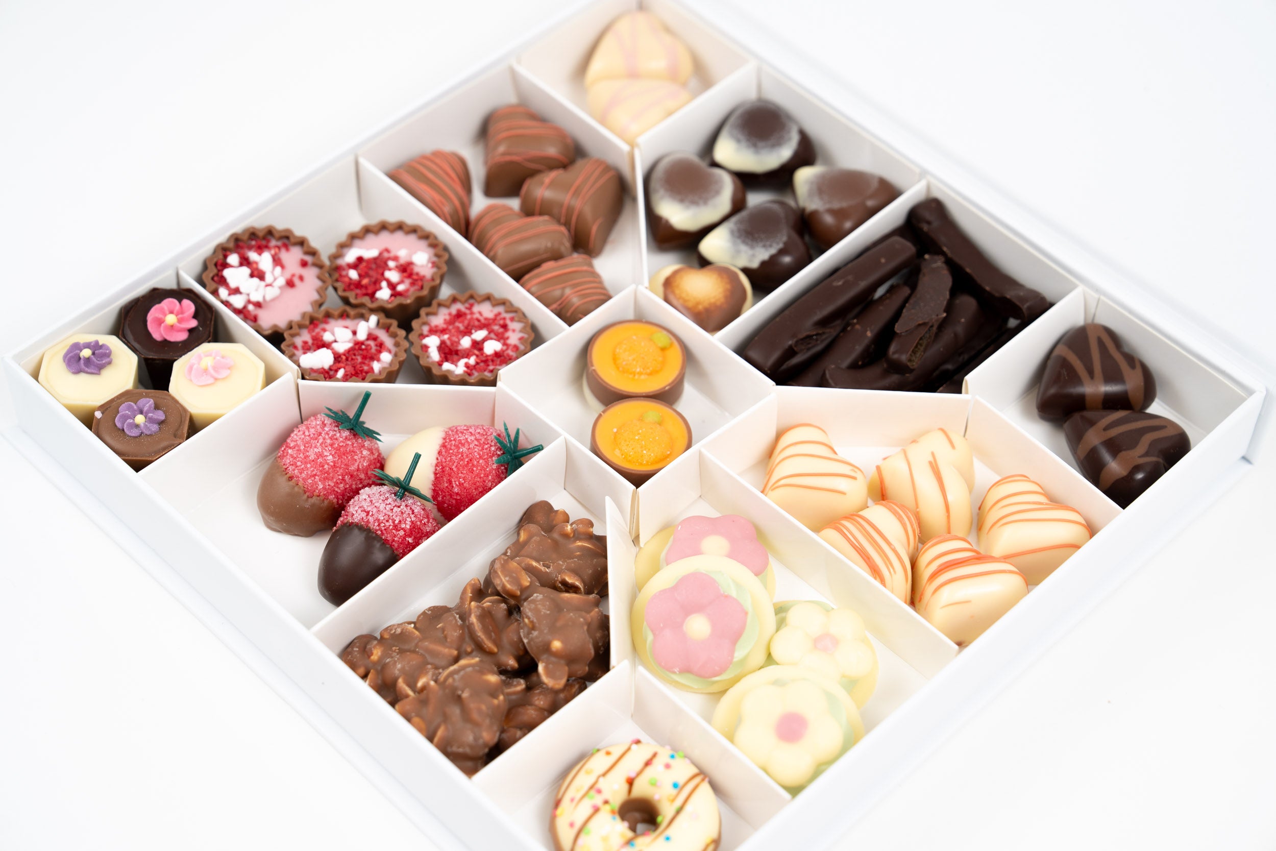 Détail d’un assortiment de chocolats artisanaux avec pralinés, ganaches fruitées et douceurs chocolatées premium