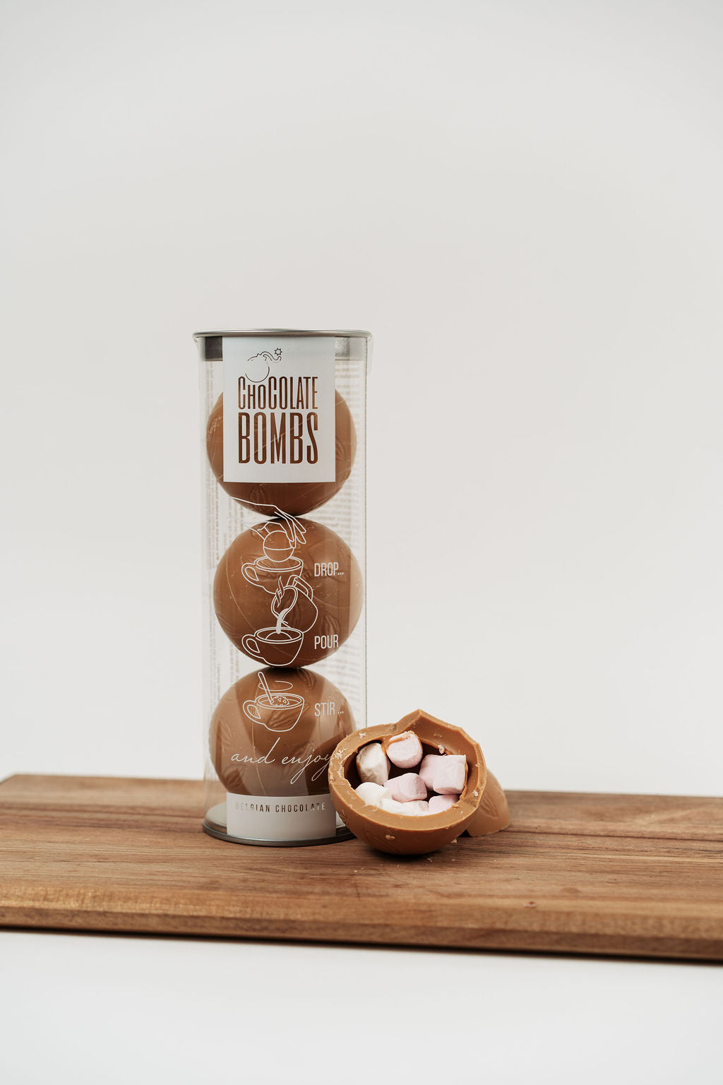 Bombe de chocolat chaud caramel avec mini marshmallows présentée avec autres bombes en arrière-plan