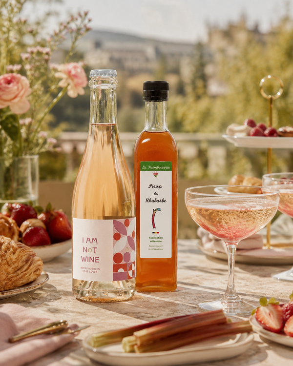 Brunch élégant avec boisson pétillante rosée sans alcool et sirop artisanal de rhubarbe dans une atmosphère lumineuse et raffinée.