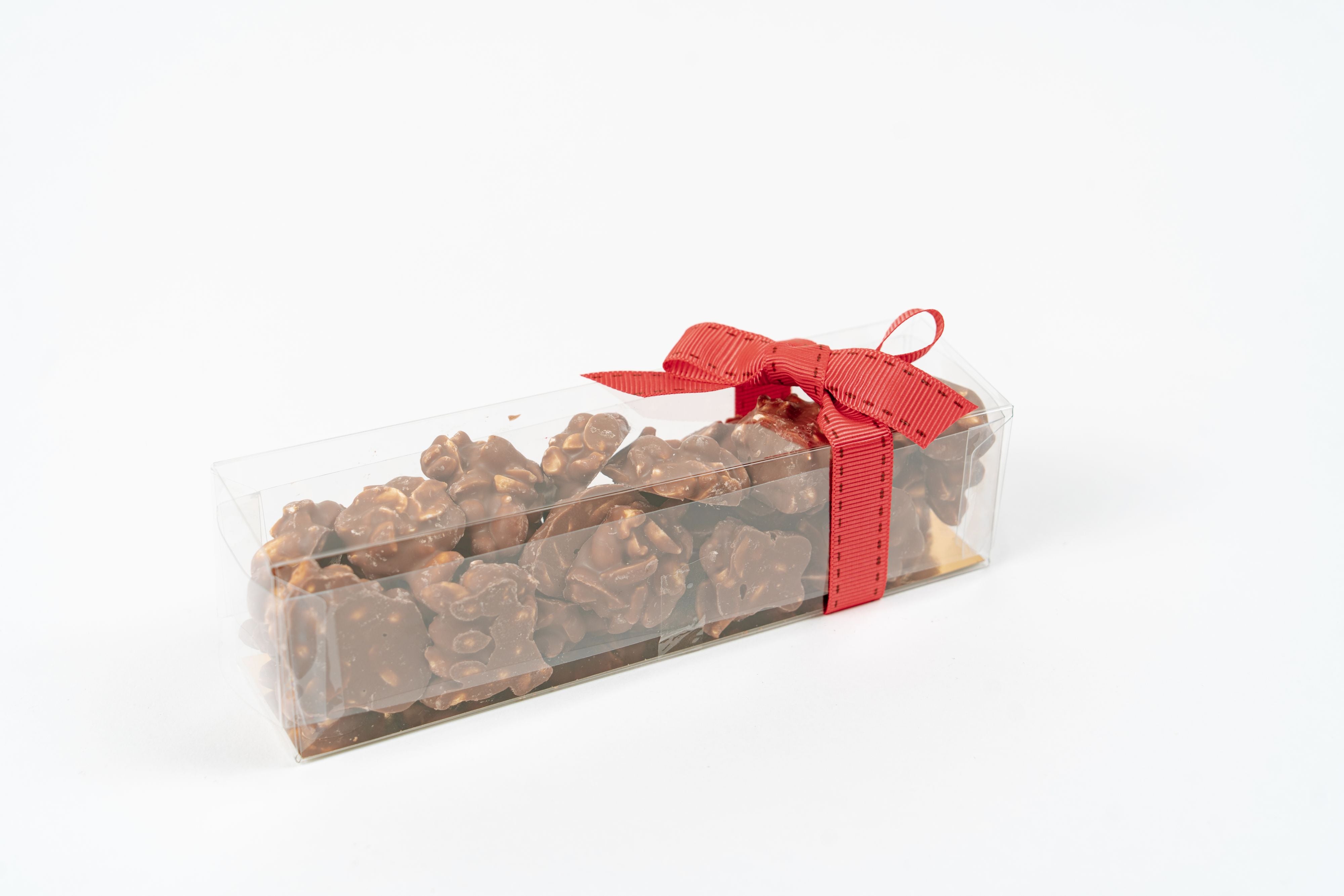 Cacahuètes enrobées de chocolat au lait présentées dans un coffret avec ruban rose