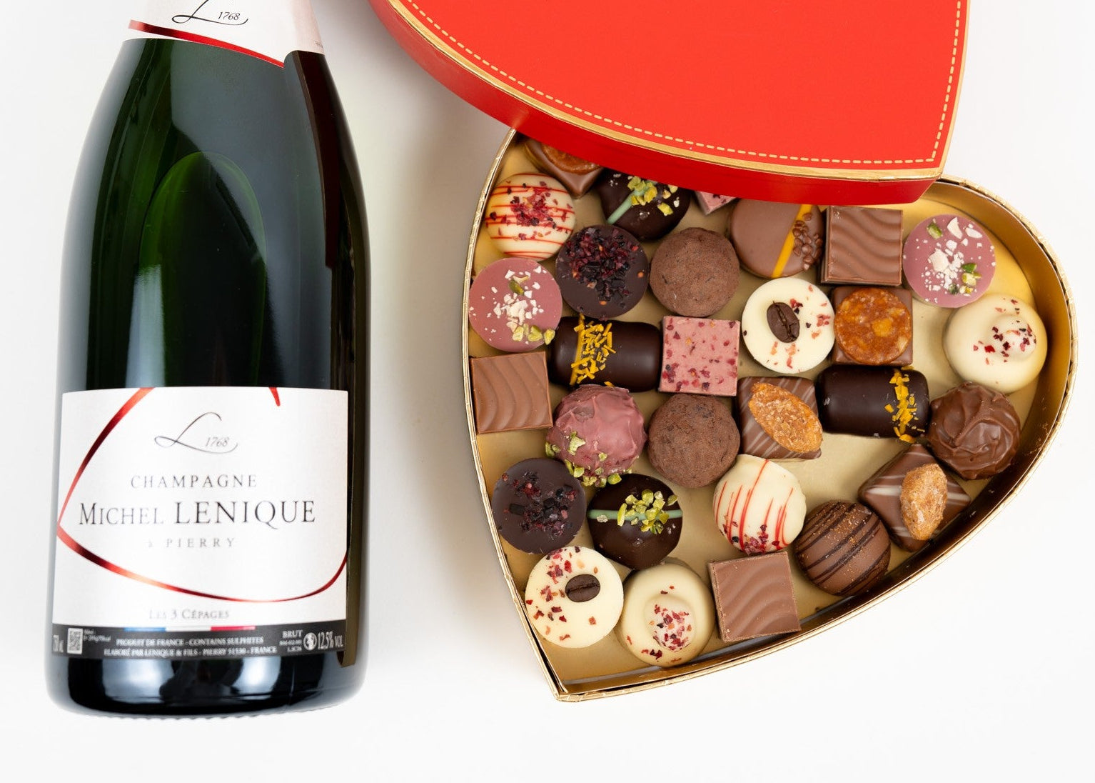 Champagne with open heart-shaped box filled with assorted praline chocolates, luxury gift set