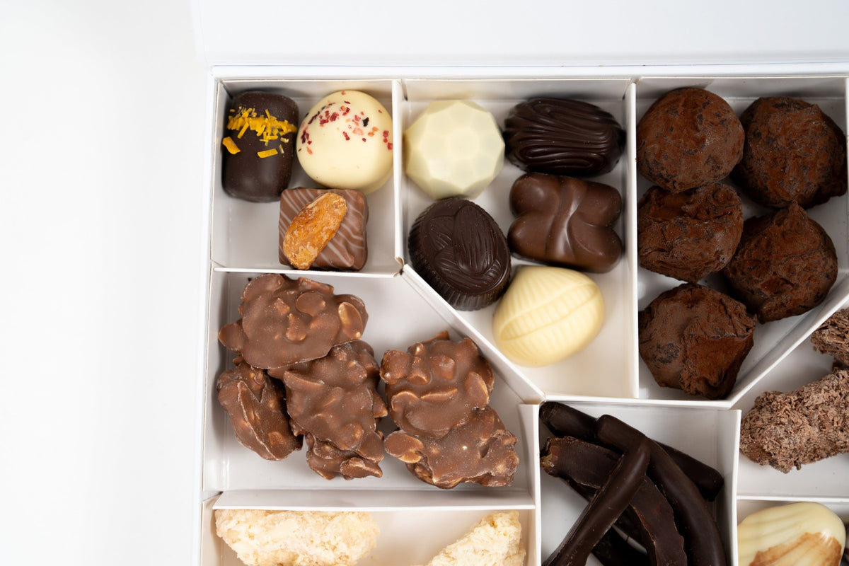 Dettaglio di cioccolatini, tartufi al cacao e arachidi ricoperte di cioccolato