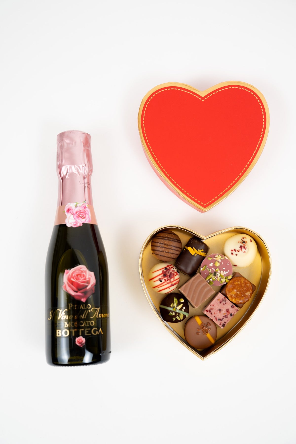 Coffret cadeau cœur rouge avec 110 g de pralines assorties et bouteille de Moscato rosé Péché Mignon