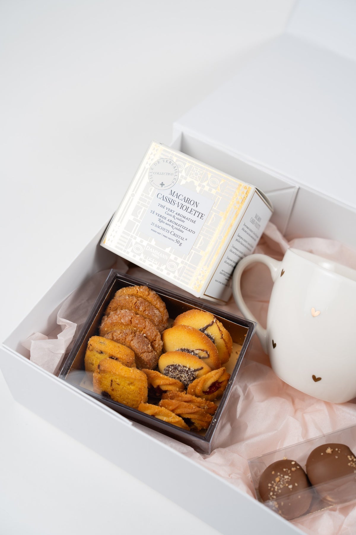 Autumn gift box detail with Dammann Frères Macaron Blackcurrant Violet Green Tea, artisan biscuits and a white gold-heart mug