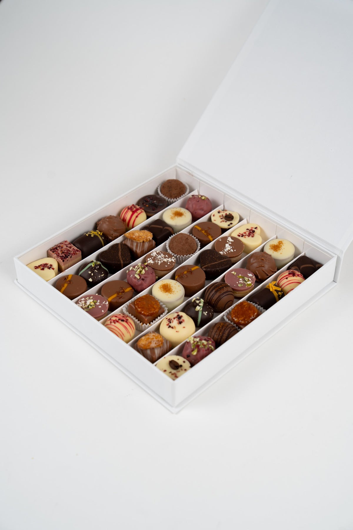 Coffret Nessi 525 g ouvert avec assortiment de pralines artisanales Péché Mignon