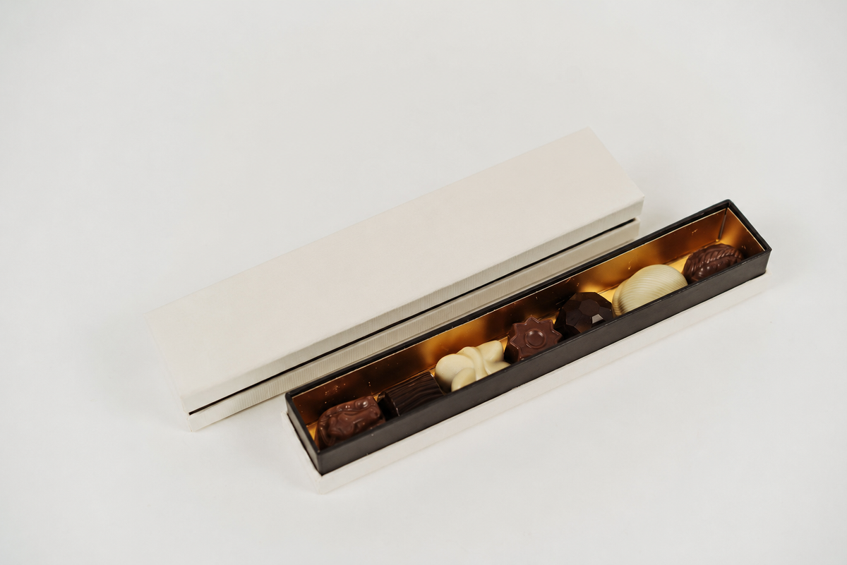 Coffret chocolat avec assortiment de pralines belges sur fond ivoire