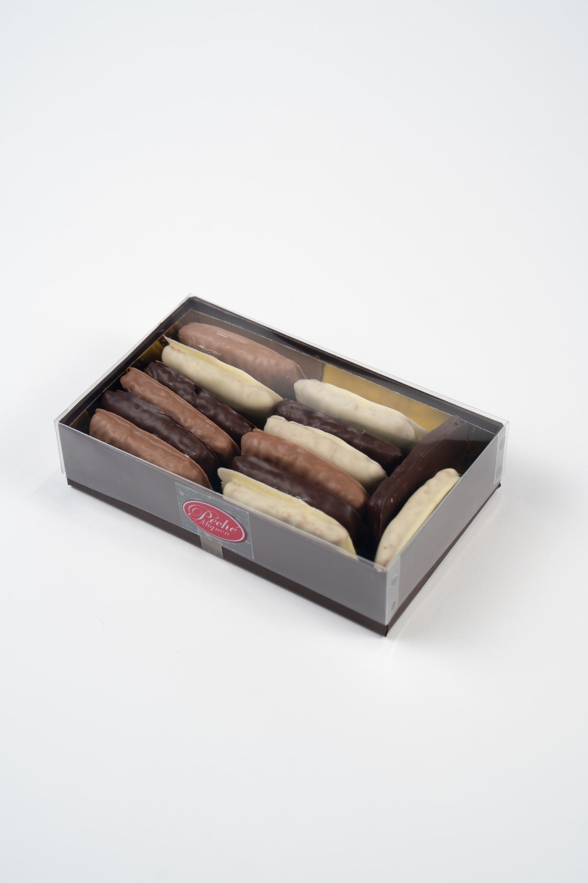 Péché Mignon-geschenkdoos met Weichprinten in pure, melk- en witte chocolade en een transparant deksel.