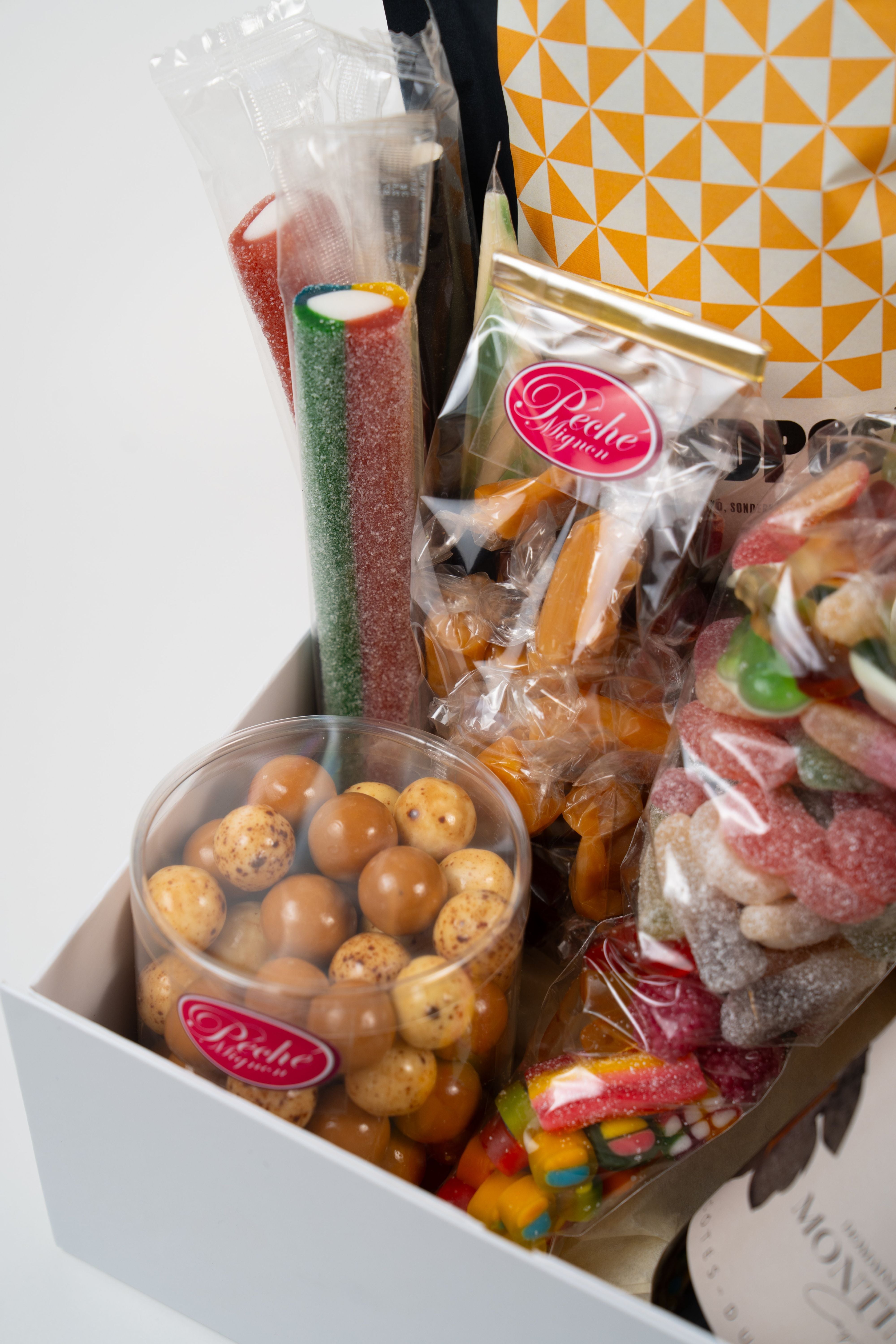 Close-up of movie night gift box with wine bottle, savoury snacks and sweets.