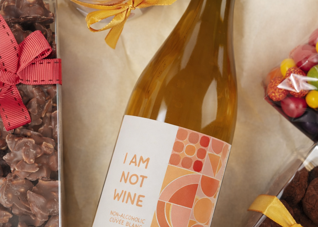 Détail bouteille vin blanc sans alcool et douceurs dans coffret cadeau