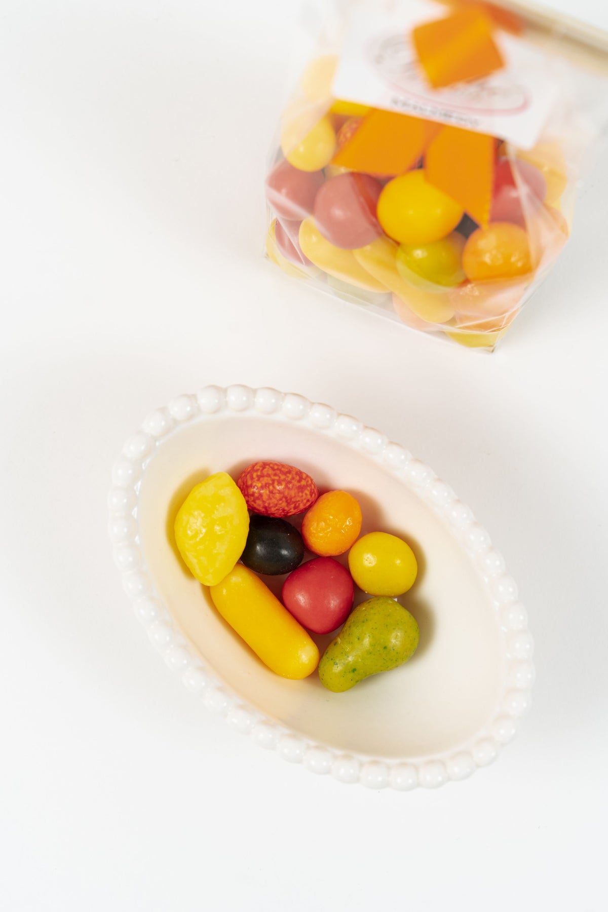 Fruits Suisses colorés dans une coupelle avec sachet Péché Mignon